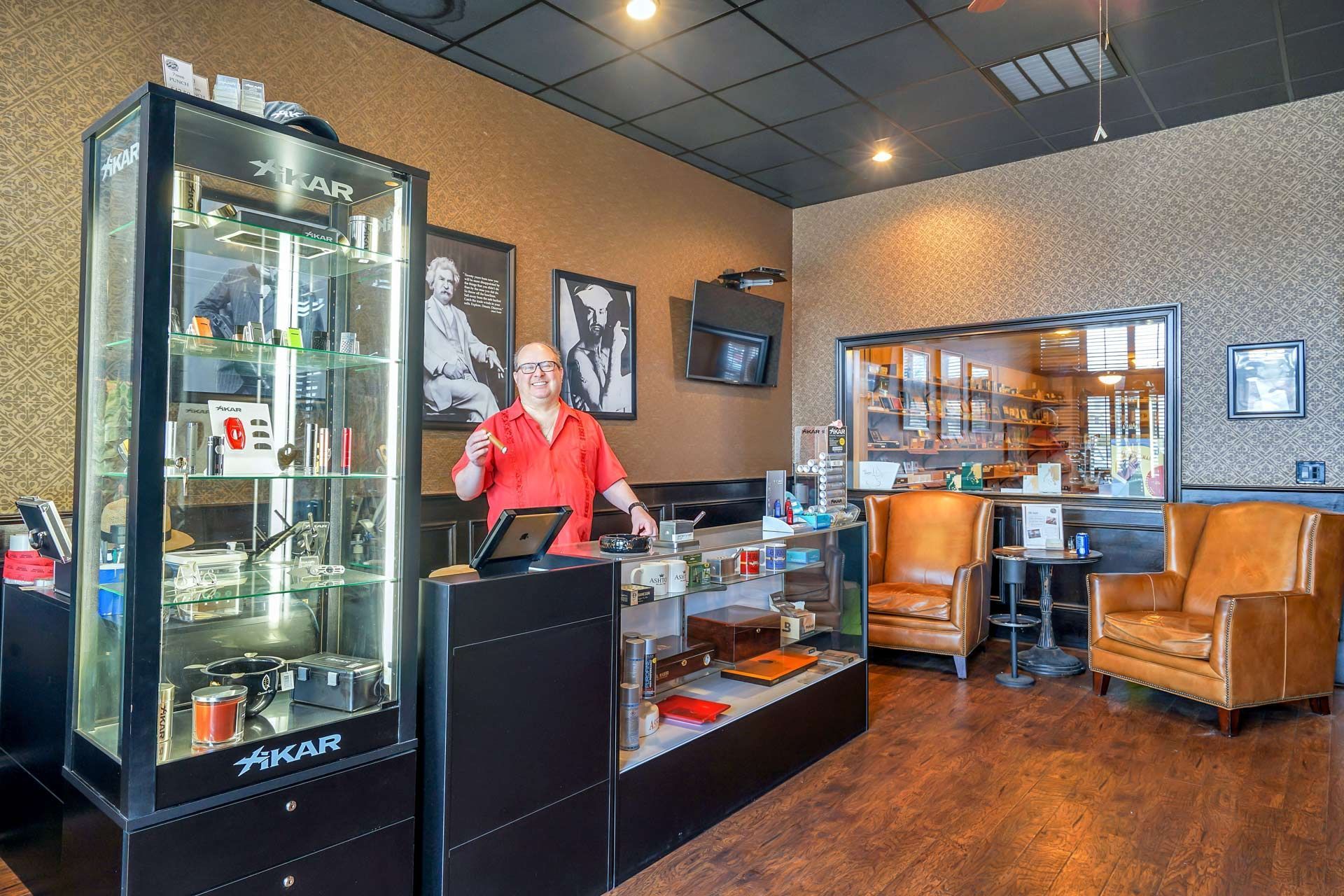 A man in a red shirt is standing at a counter in a store
