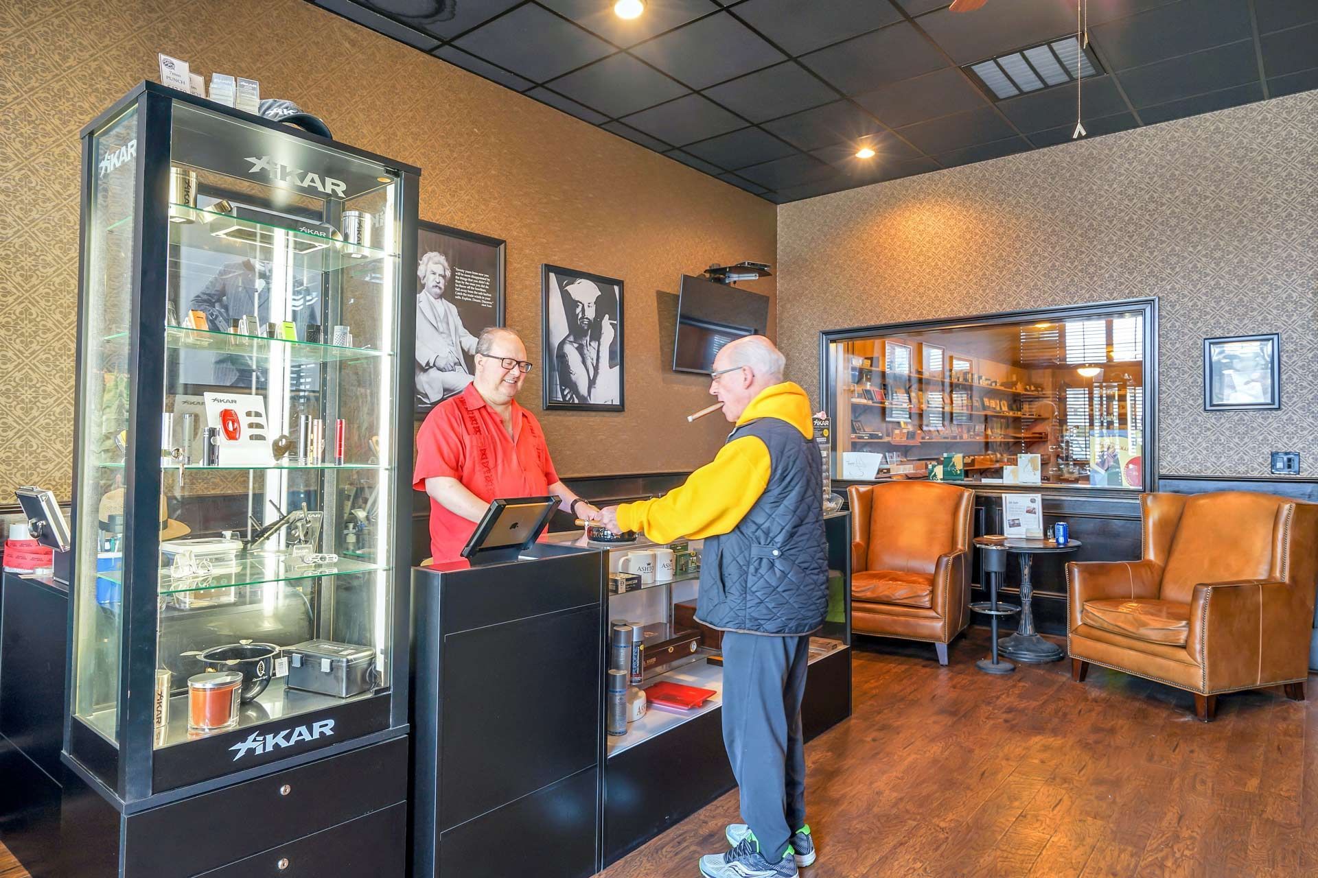 A man is standing at a counter in a store talking to another man