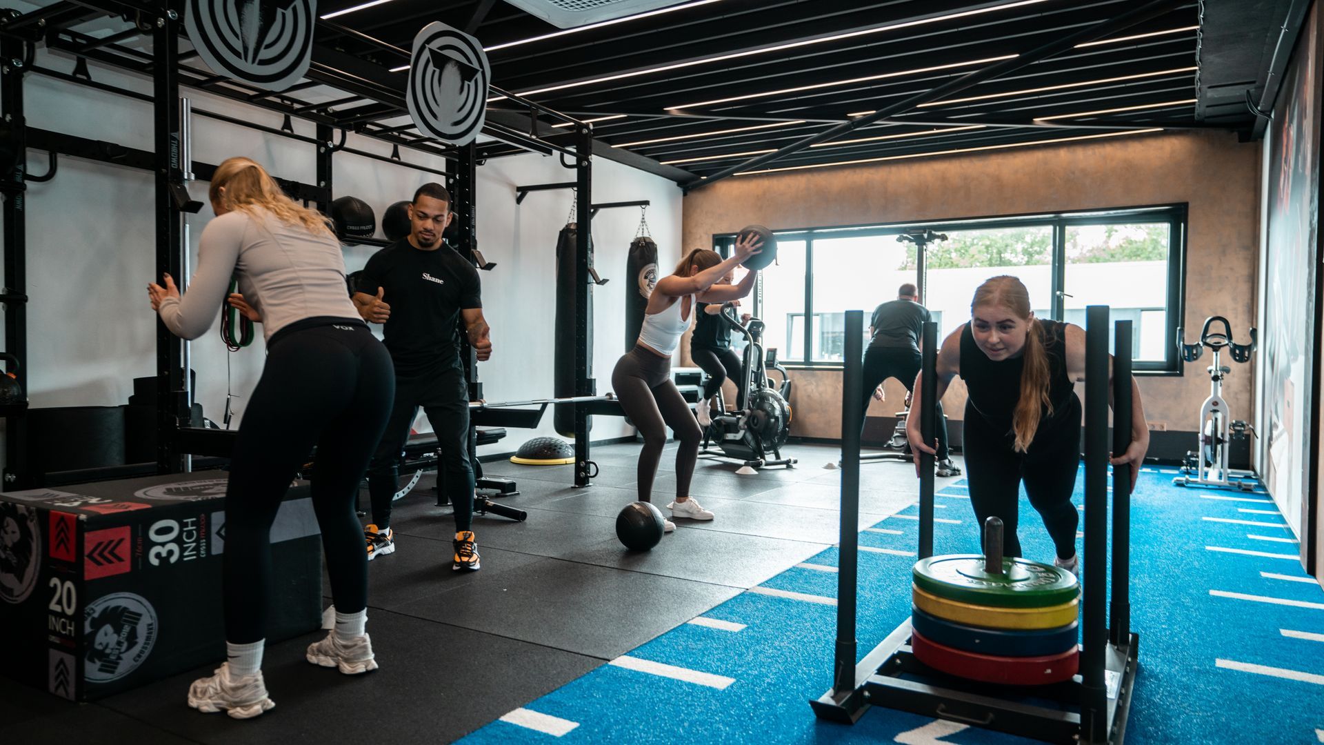 Een man staat naast een vrouw op een loopband in een sportschool.