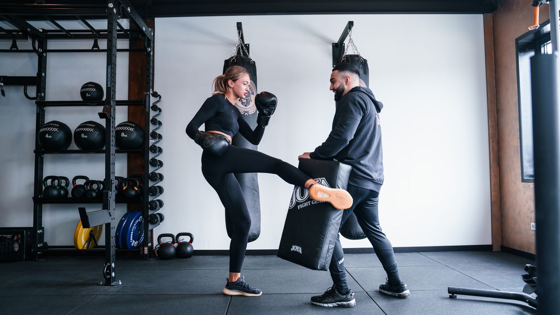 Een man en een vrouw zijn aan het boksen in een sportschool.