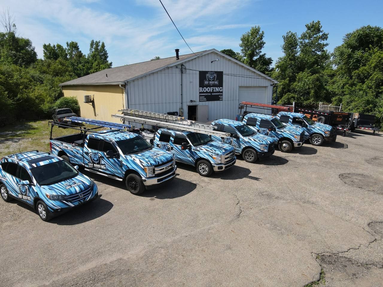 A row of blue trucks are parked in front of a building