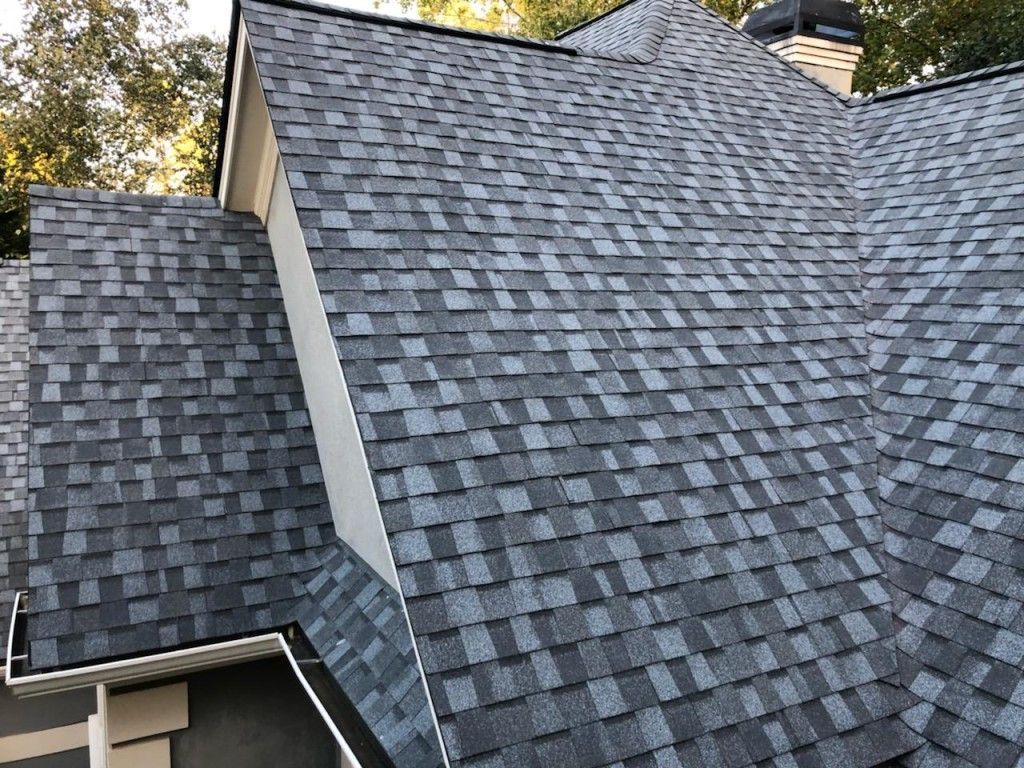 A close up of a gray shingle roof on a house.