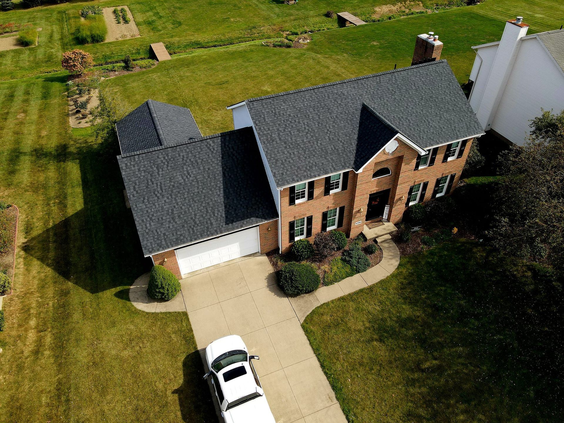 An aerial view of a house with a black roof