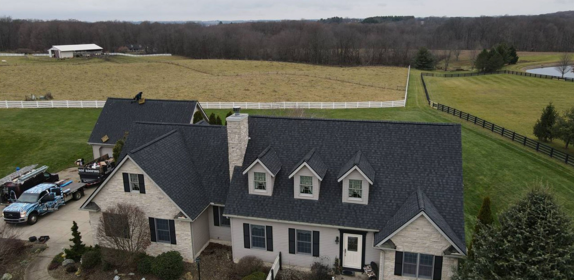 An aerial view of a house with a man standing on the roof