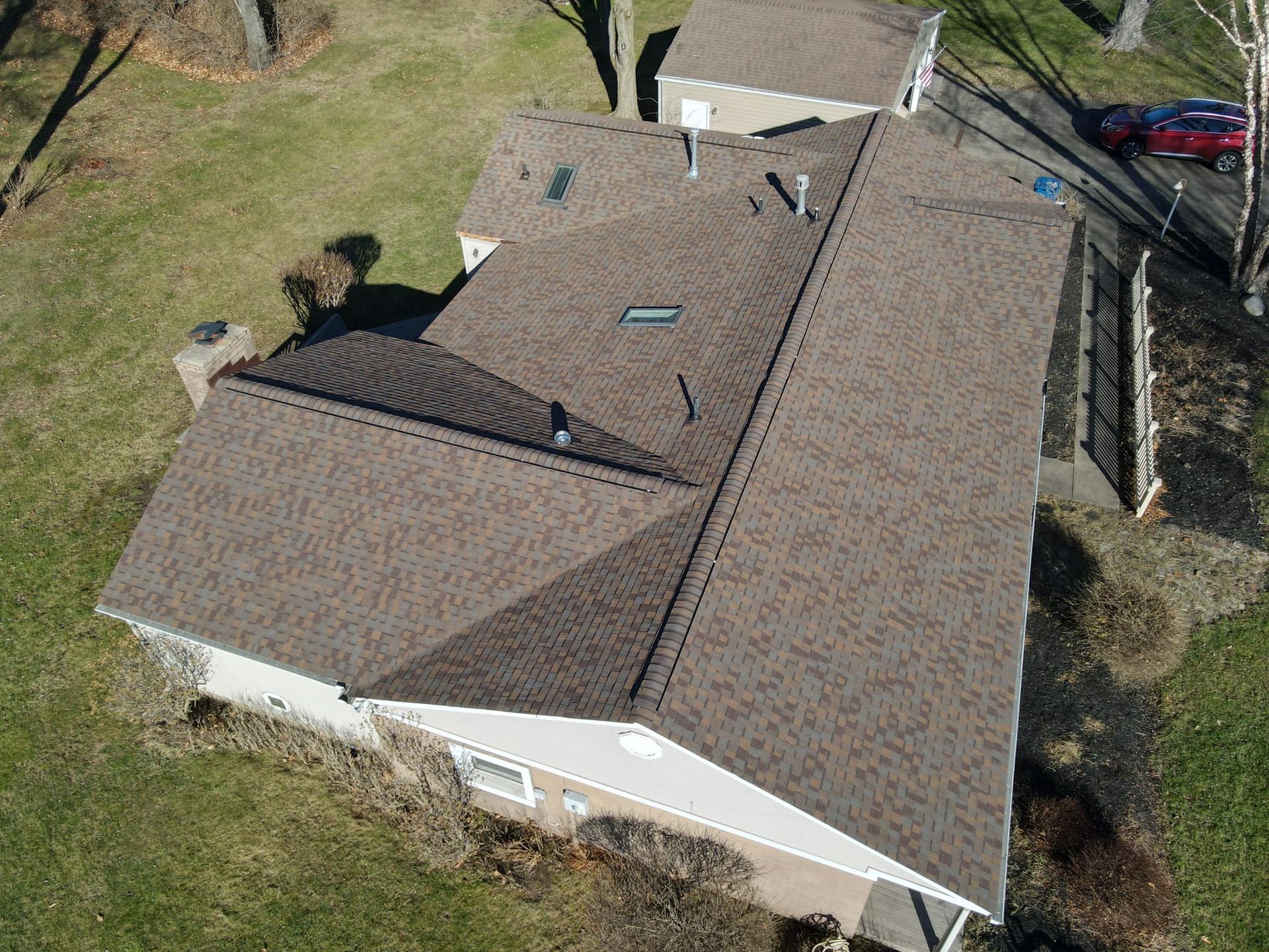 An aerial view of a white house with a gray roof