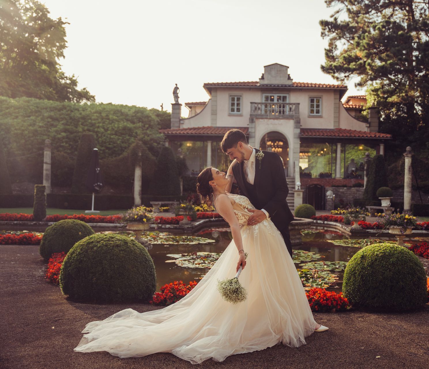 A bride and groom kissing in front of a house