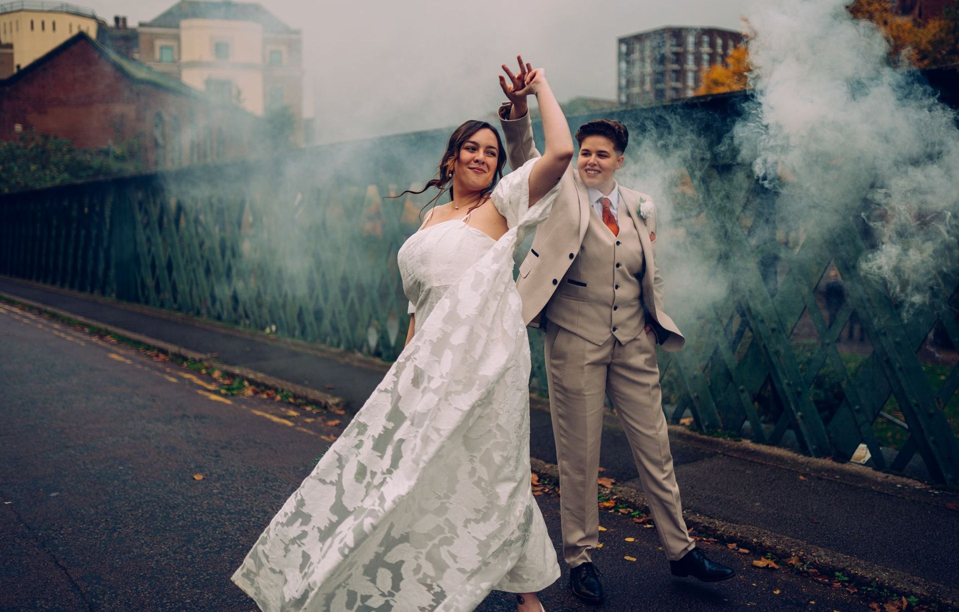 A bride and groom are dancing on the side of the road.