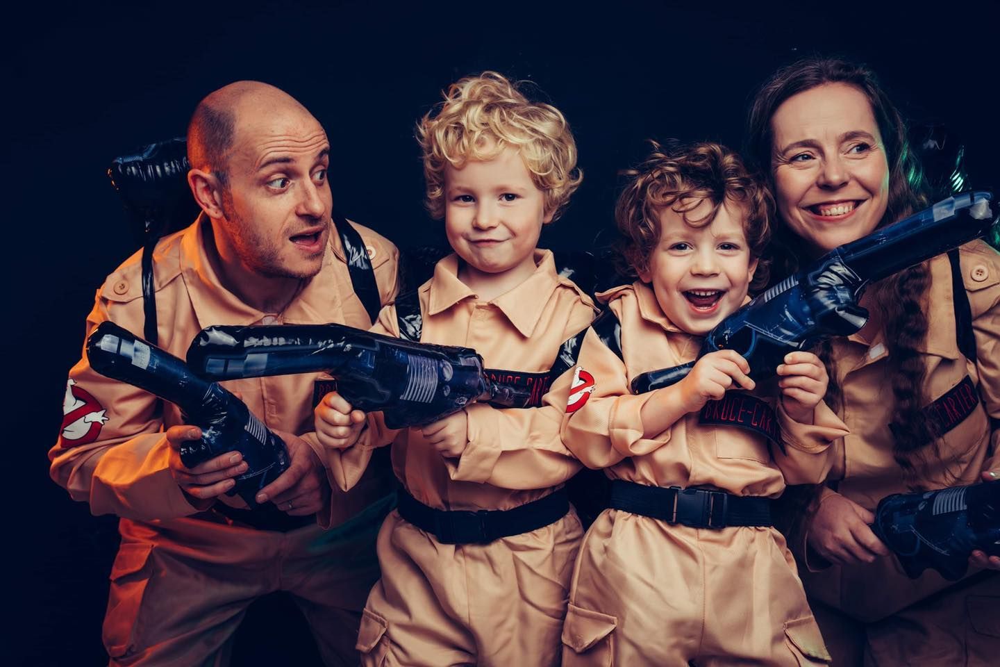 A family dressed as ghostbusters is posing for a picture.