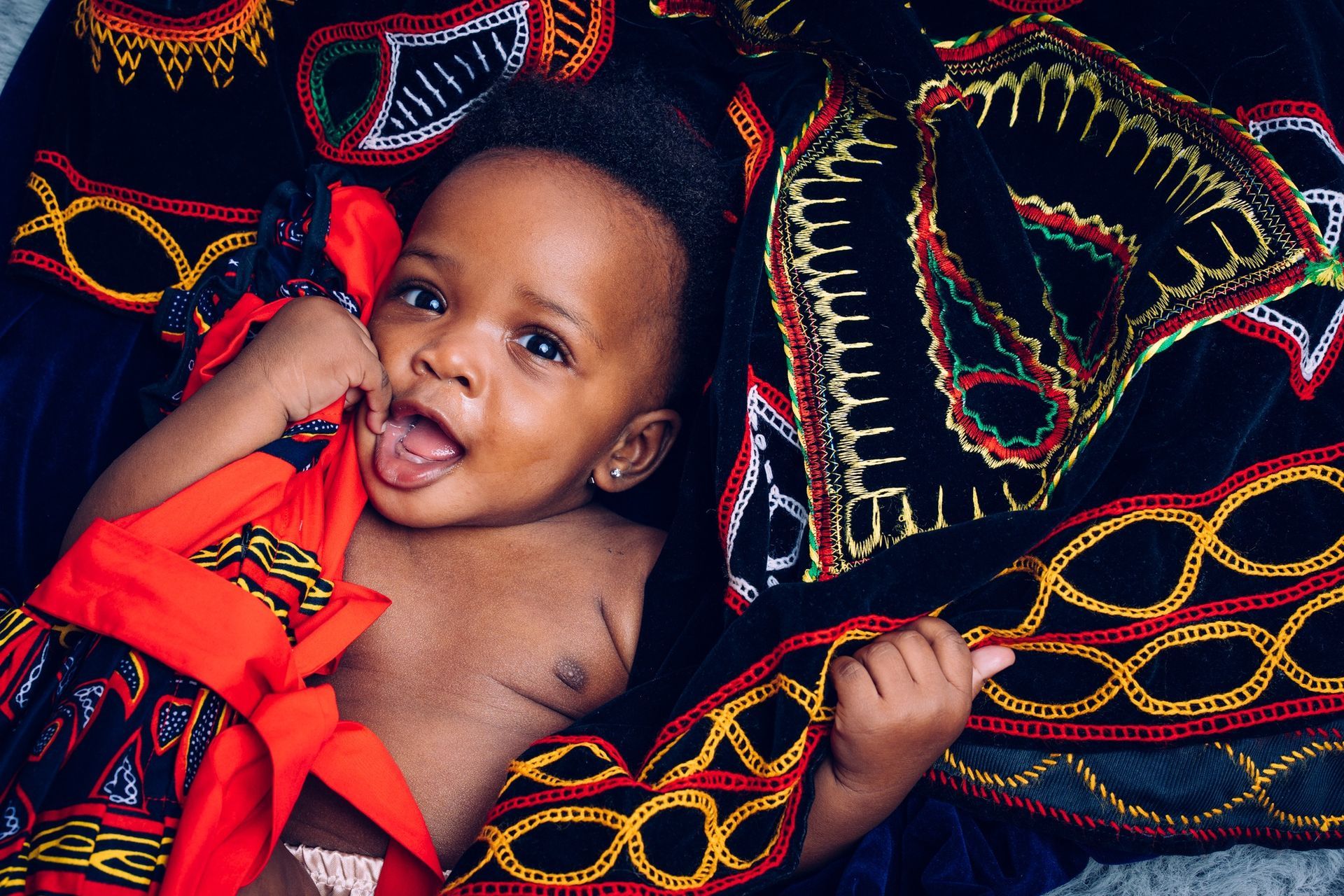 small child wrappeed in black and red clothes
