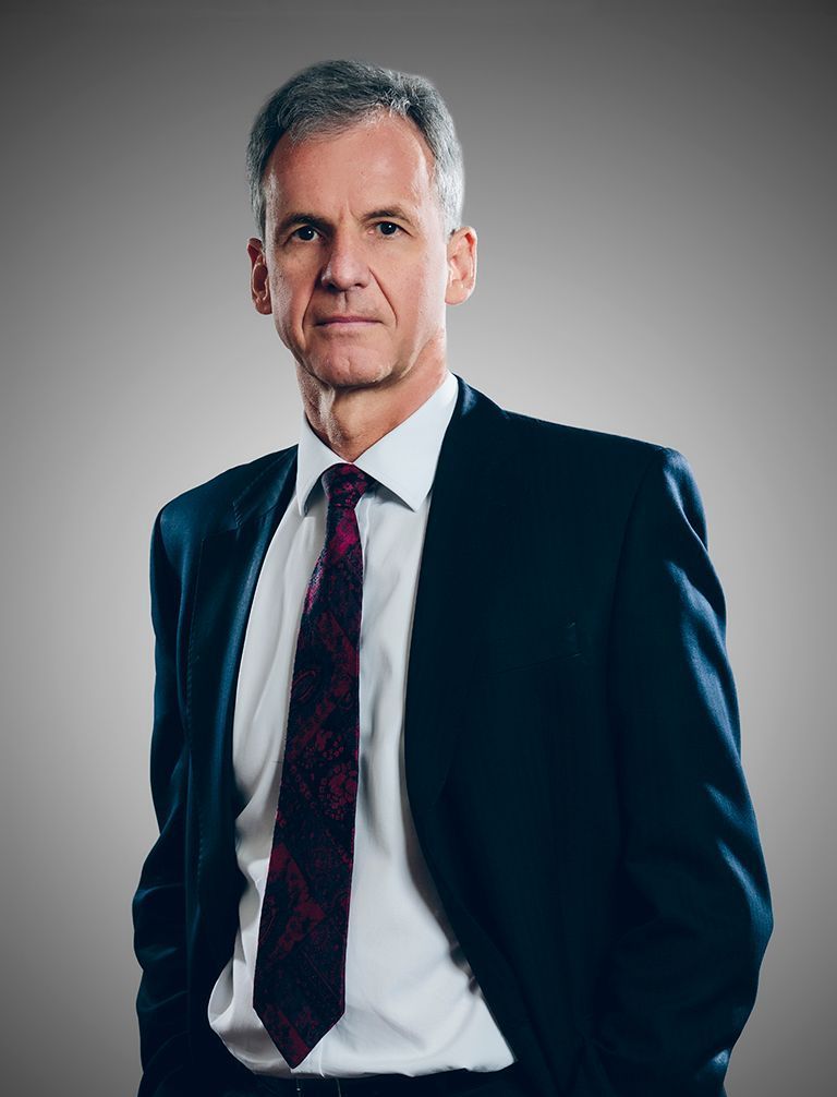 A man in a suit and tie with his hands in his pockets