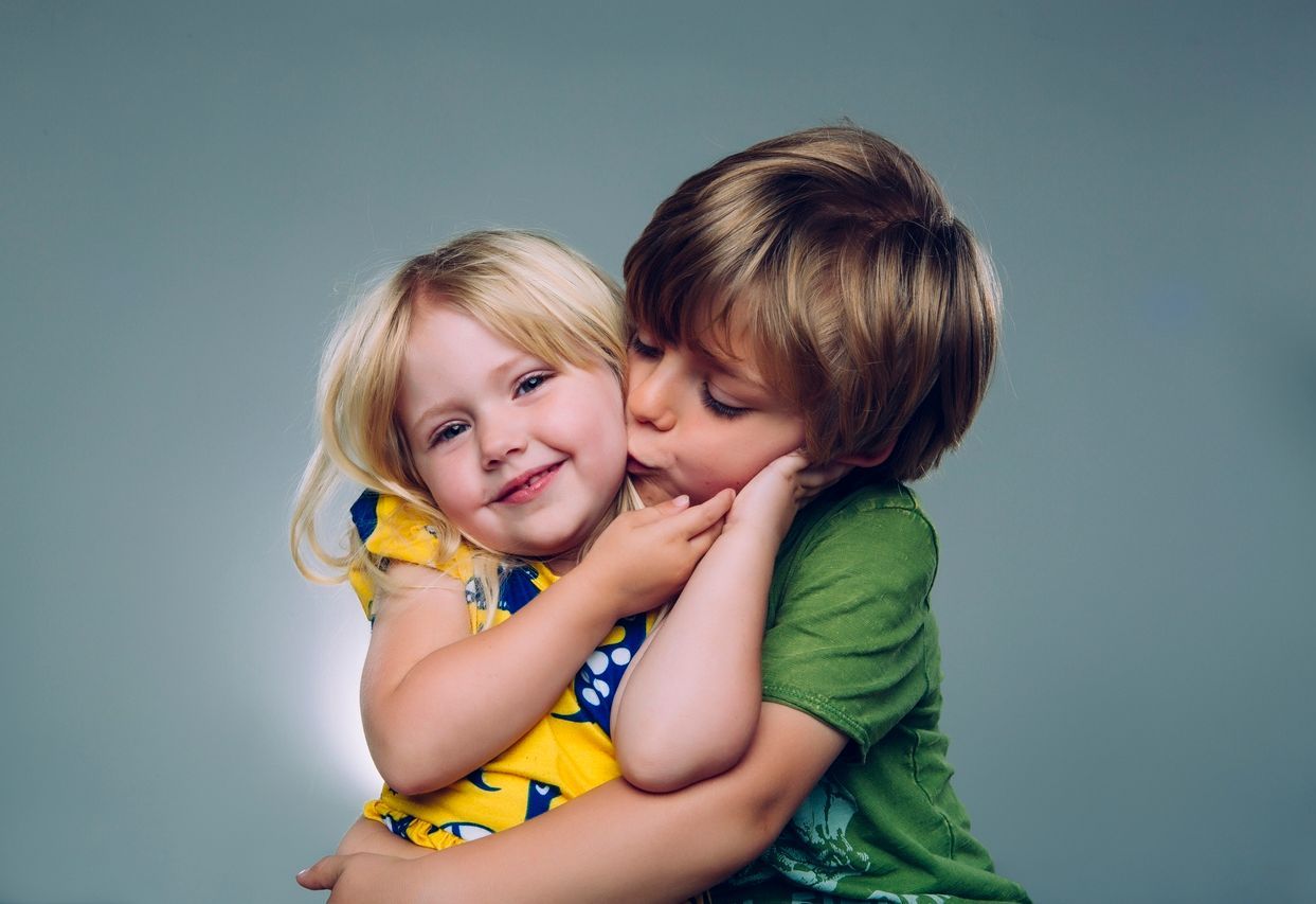 two young siblings hugging