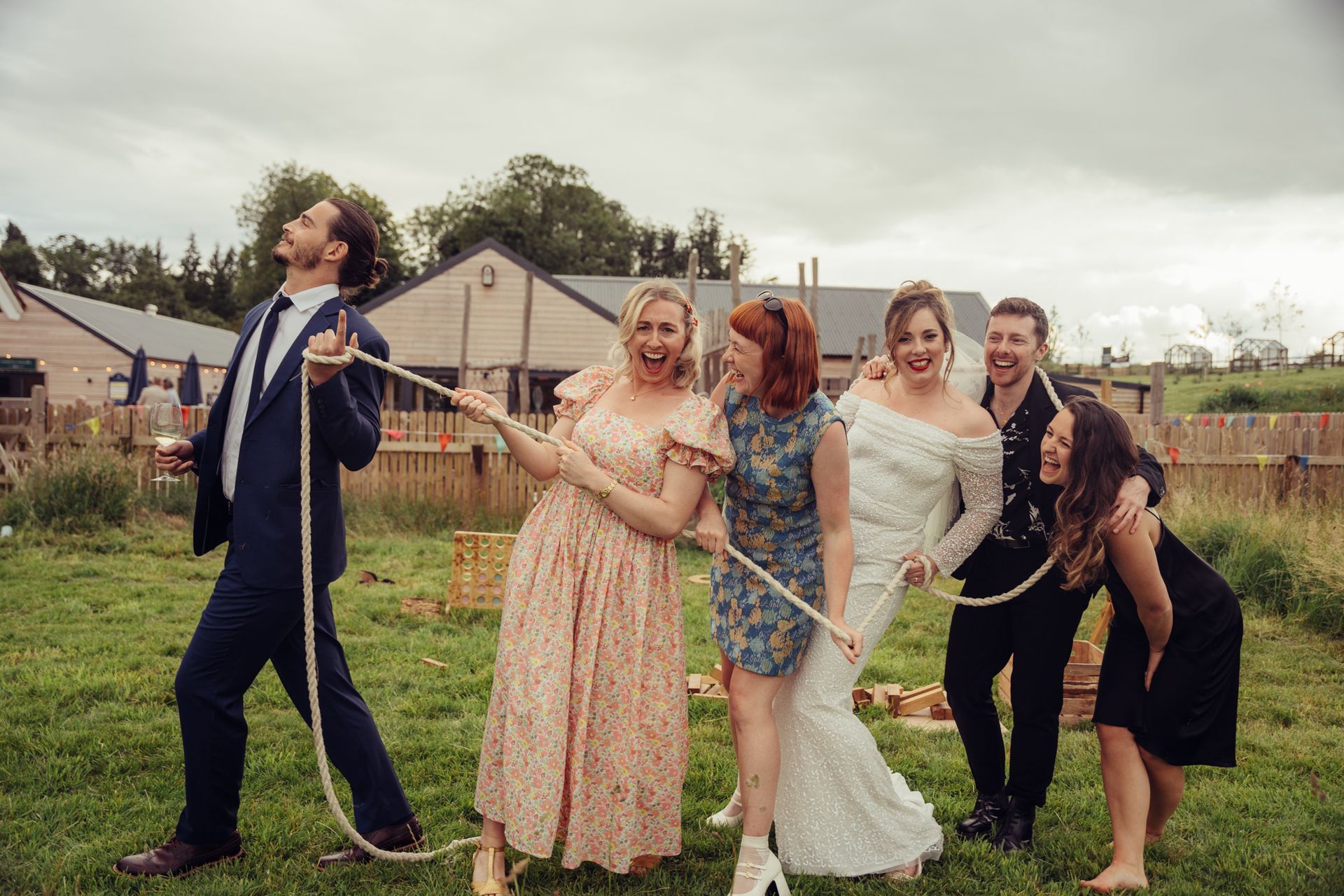 A group of people standing next to each other in a field holding ropes.