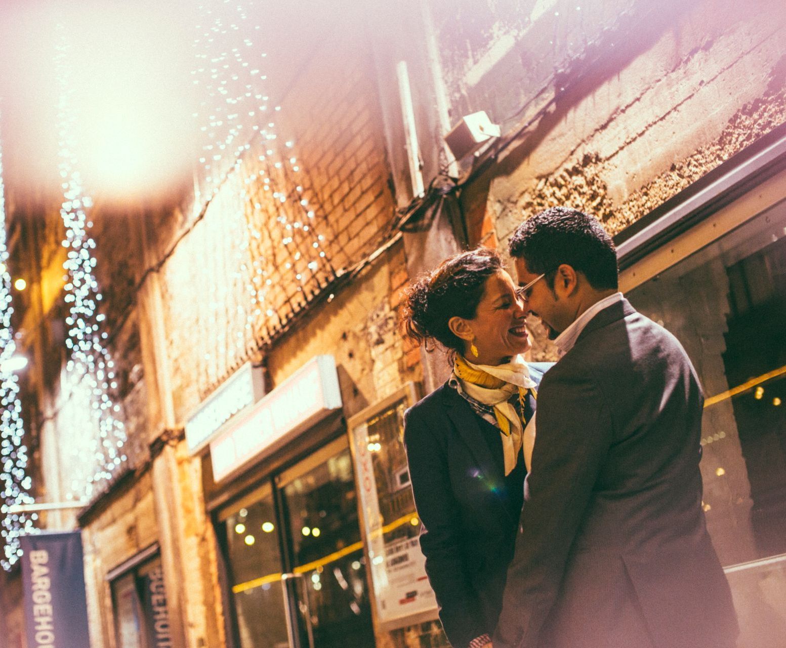 A man and a woman are standing next to each other in front of a building.
