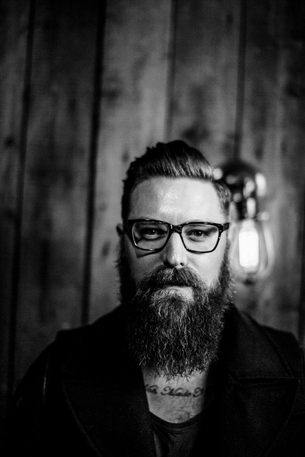 A black and white photo of a man with a beard and glasses.