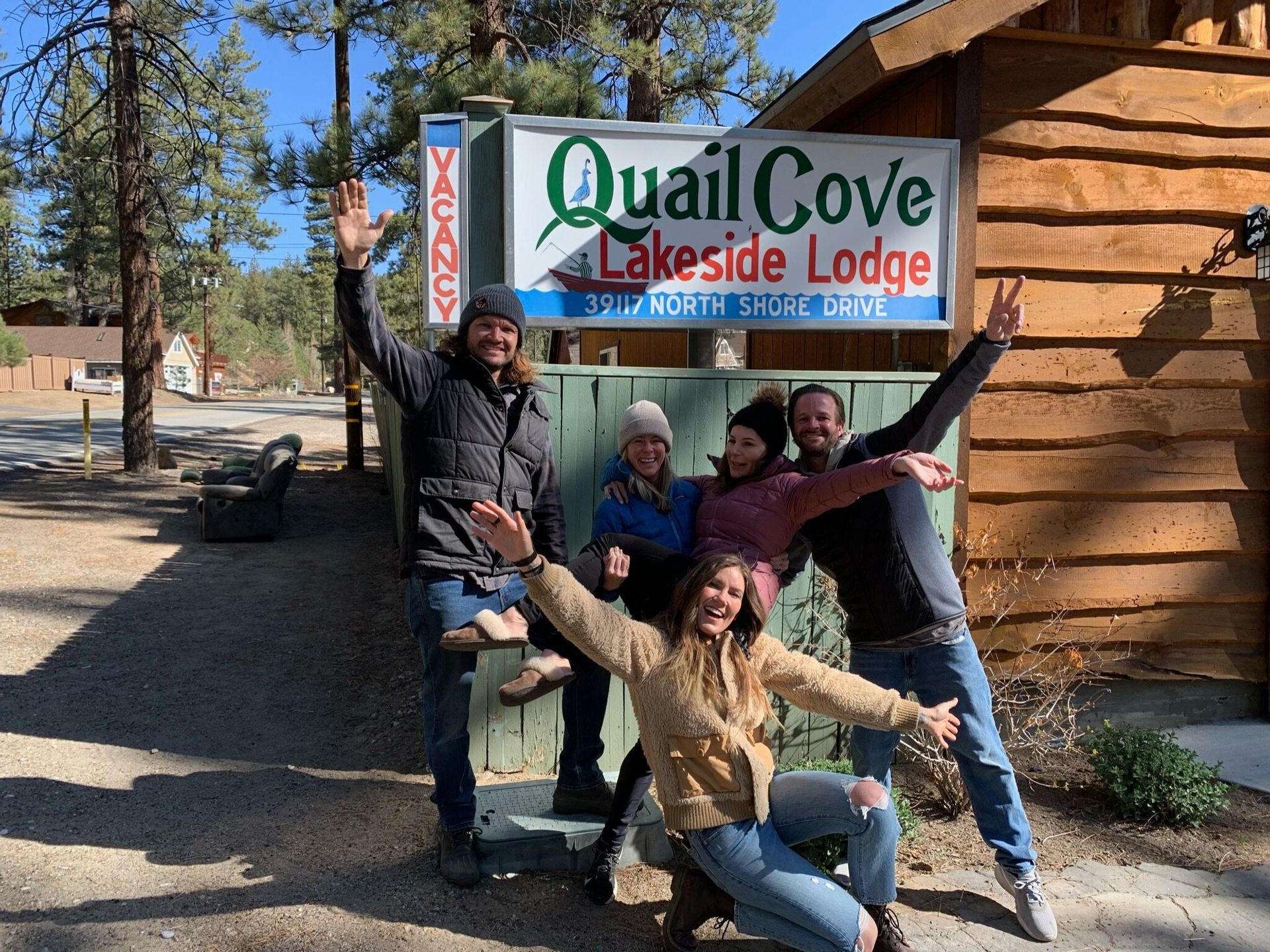 Group of people smiling and waving in front of