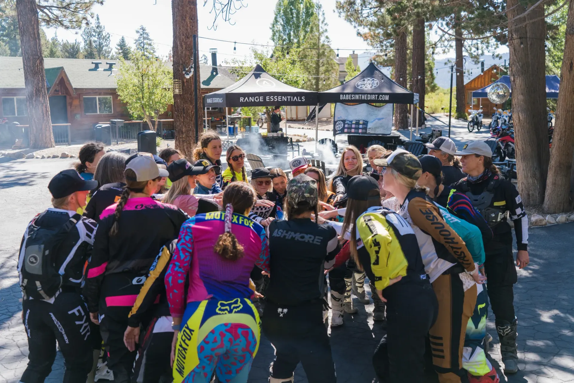 Group of people in colorful athletic wear huddled together outdoors.