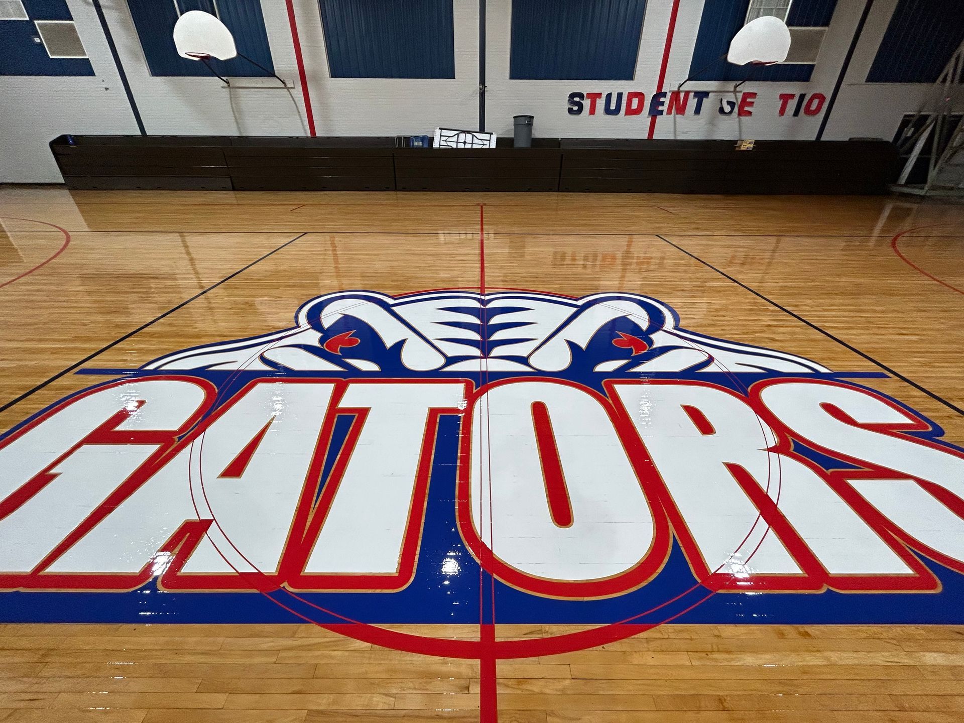 A gators logo is painted on the floor of a gym