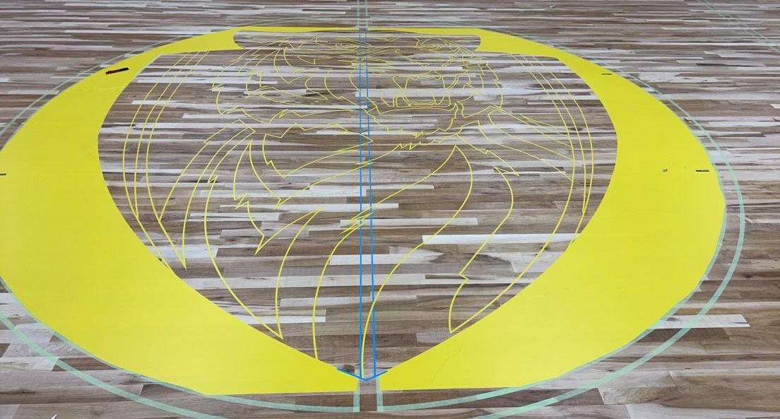 A yellow circle is painted on a wooden surface.