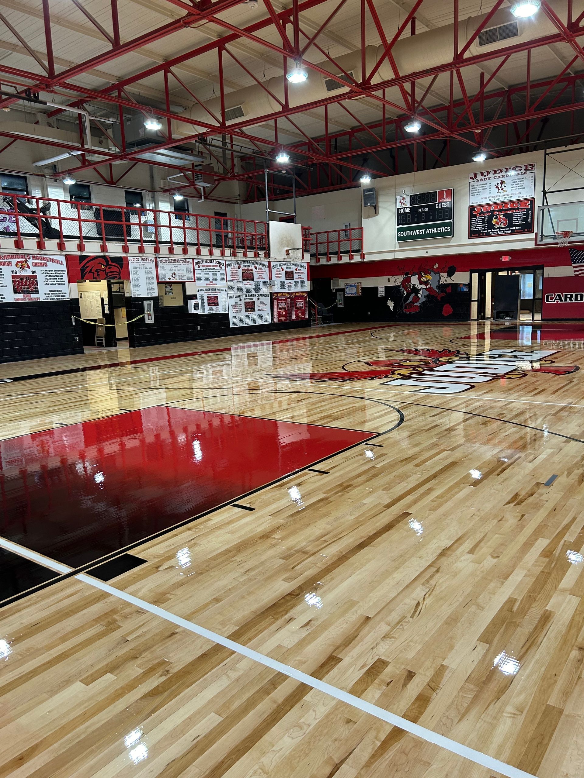 A basketball court in a gym with a wooden floor.