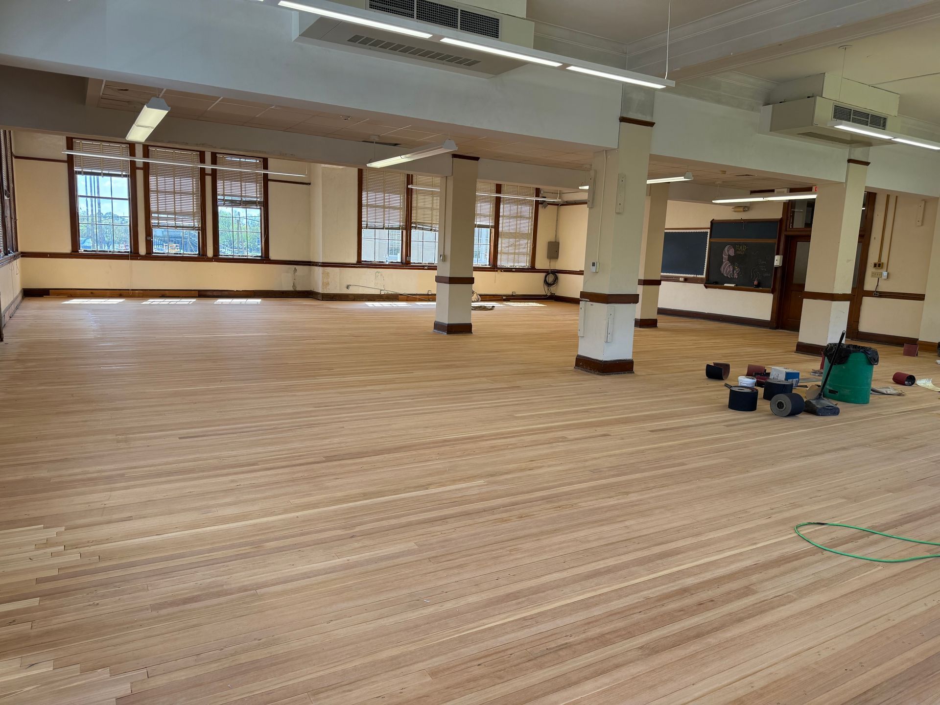 A large room with a wooden floor and a lot of windows