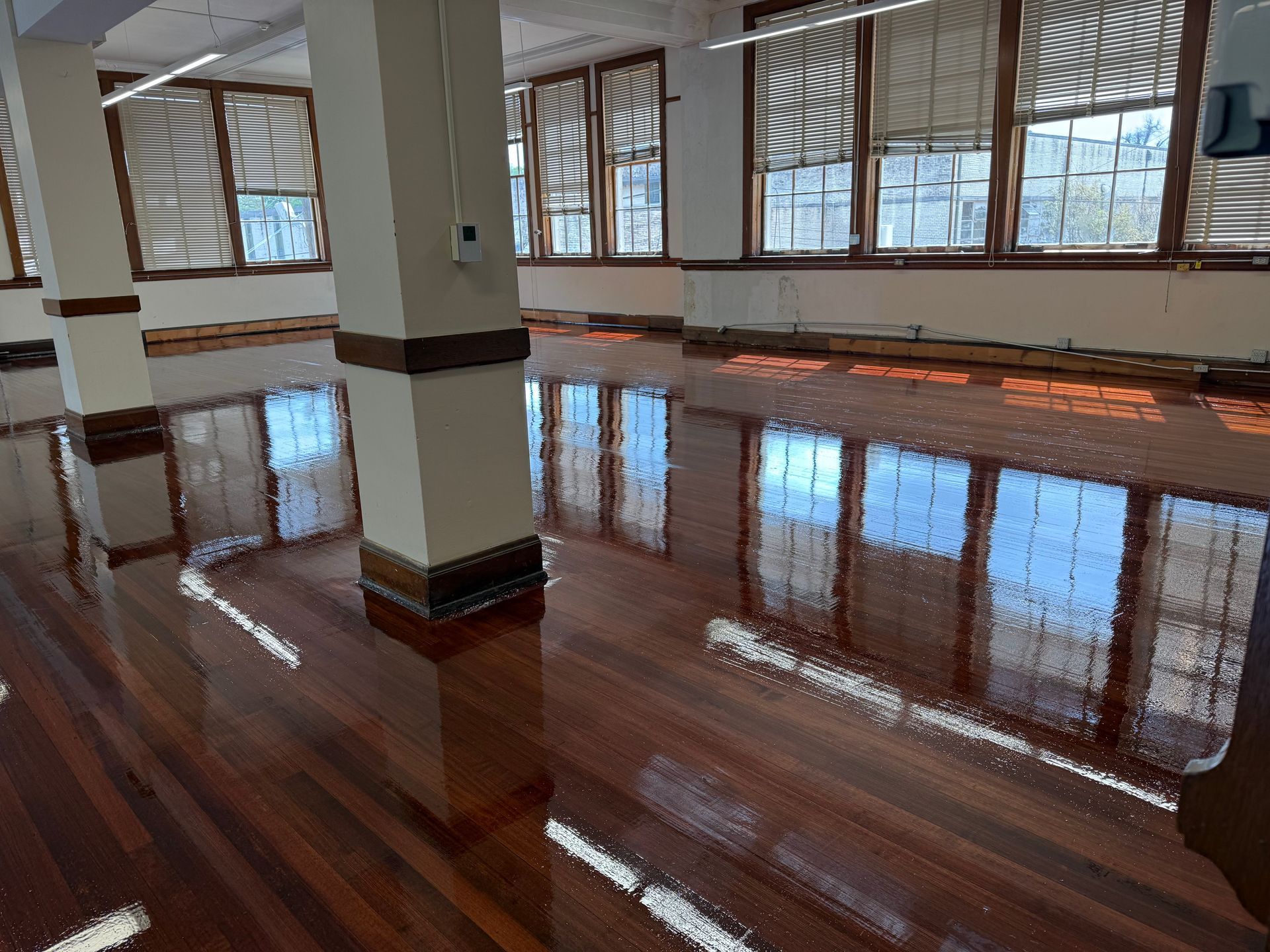 A large room with lots of windows and a wooden floor