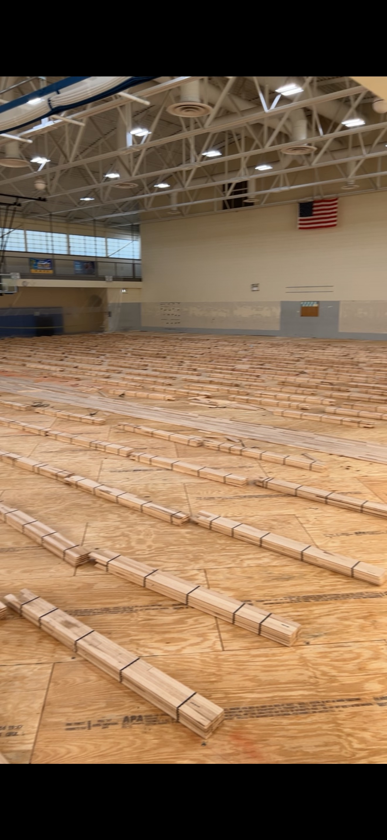 A large empty gym with a lot of wooden blocks on the floor.