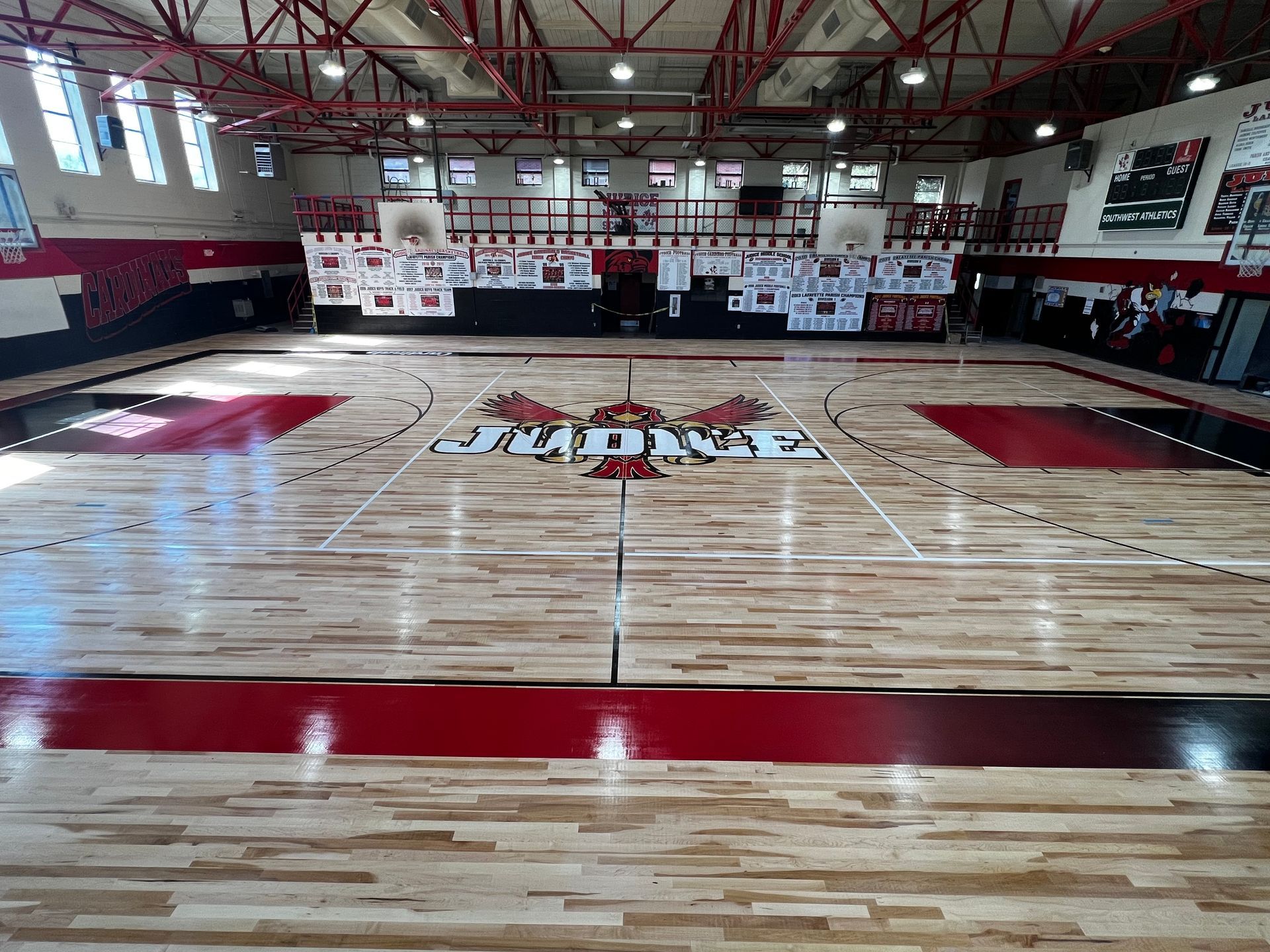 A basketball court in a gym with a wooden floor.