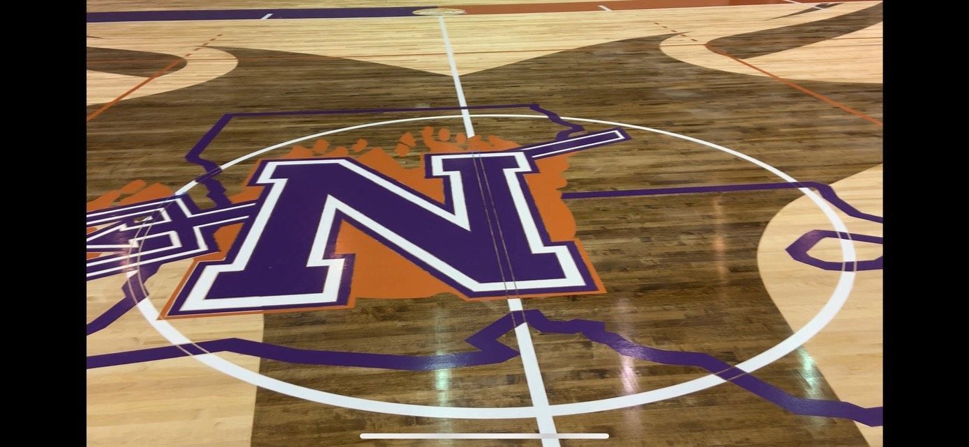 A basketball court with a purple and orange logo on it.