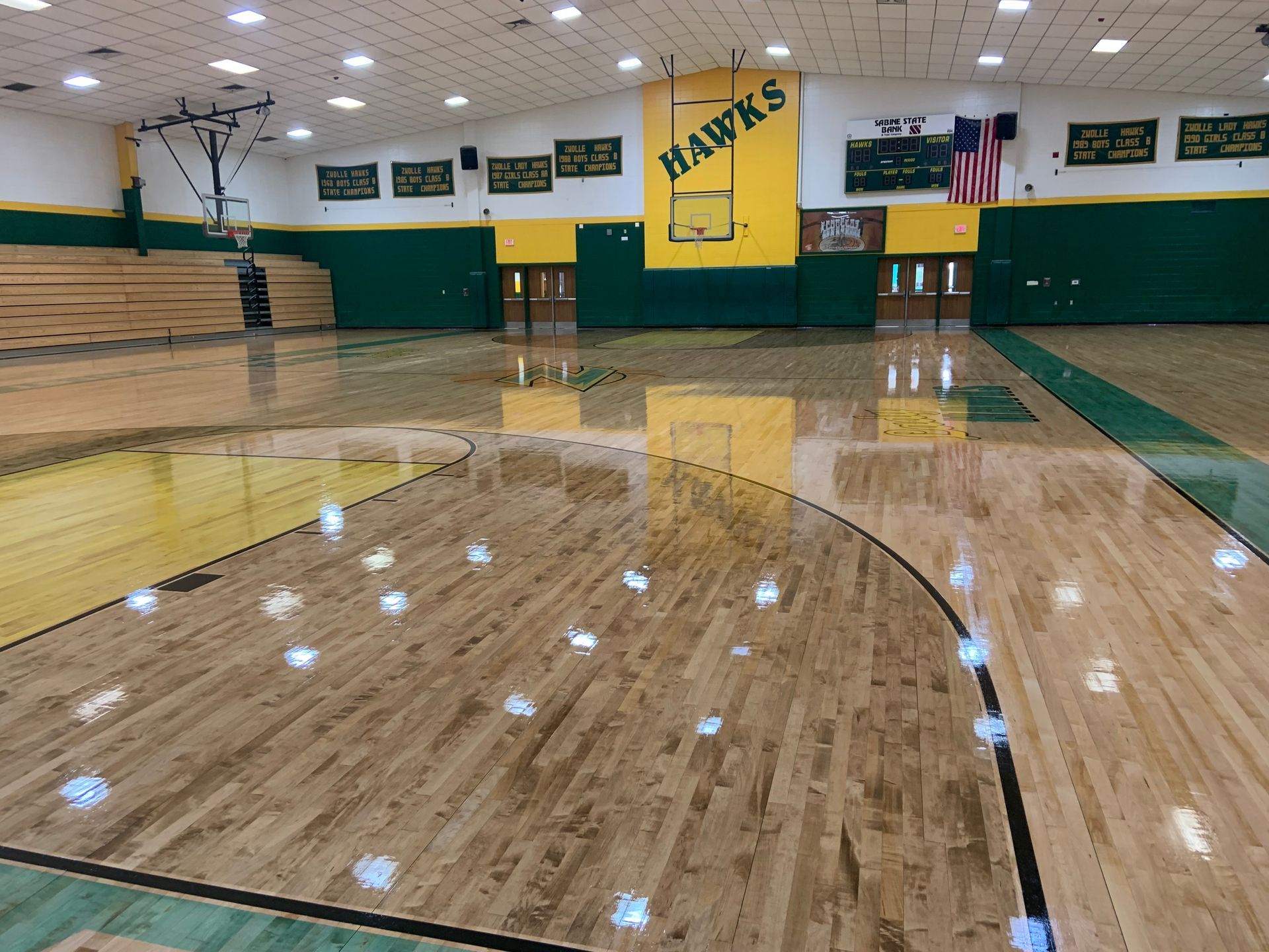 A basketball court with a hawks logo on the wall