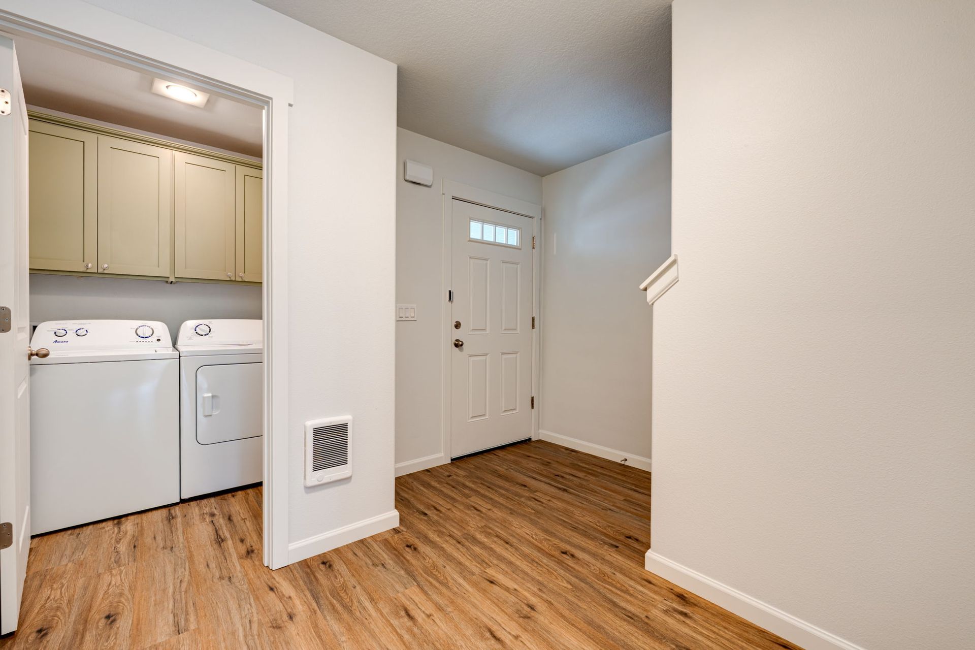 entryway with view of front door in the background and laundry closet
