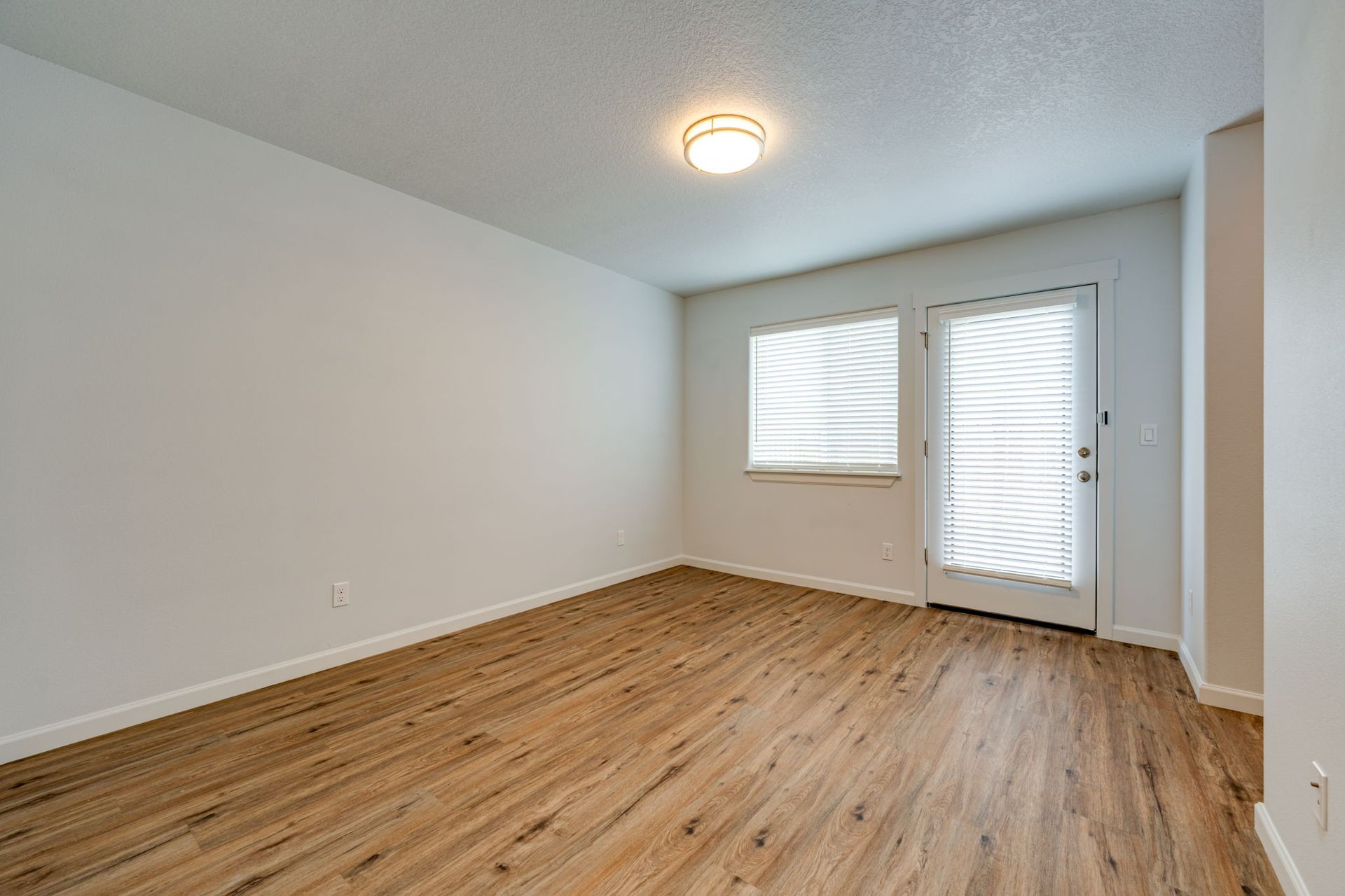 ground floor bedroom unfurnished with window and pation door in the background