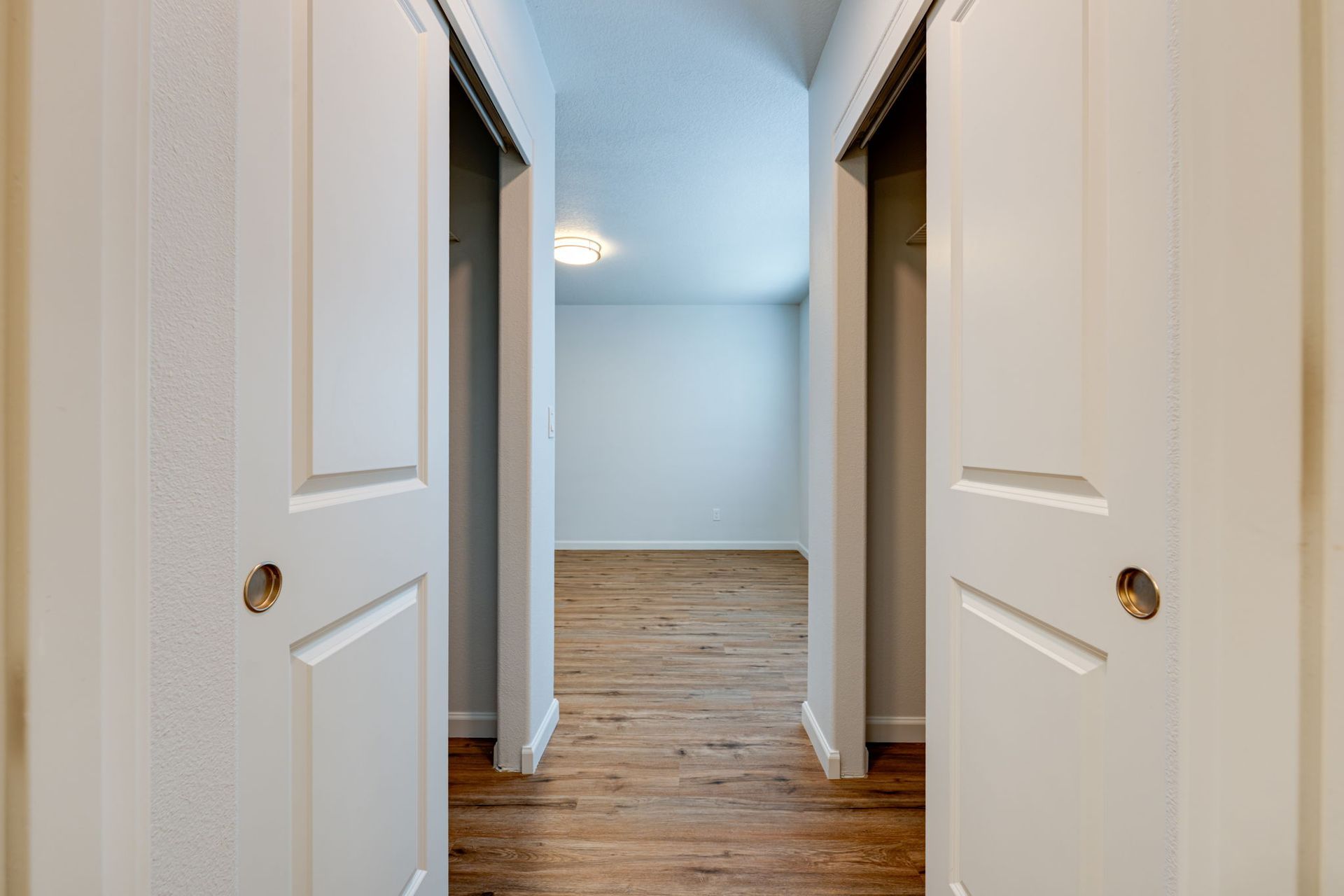 view of hallway closets with ground floor bedroom in the background