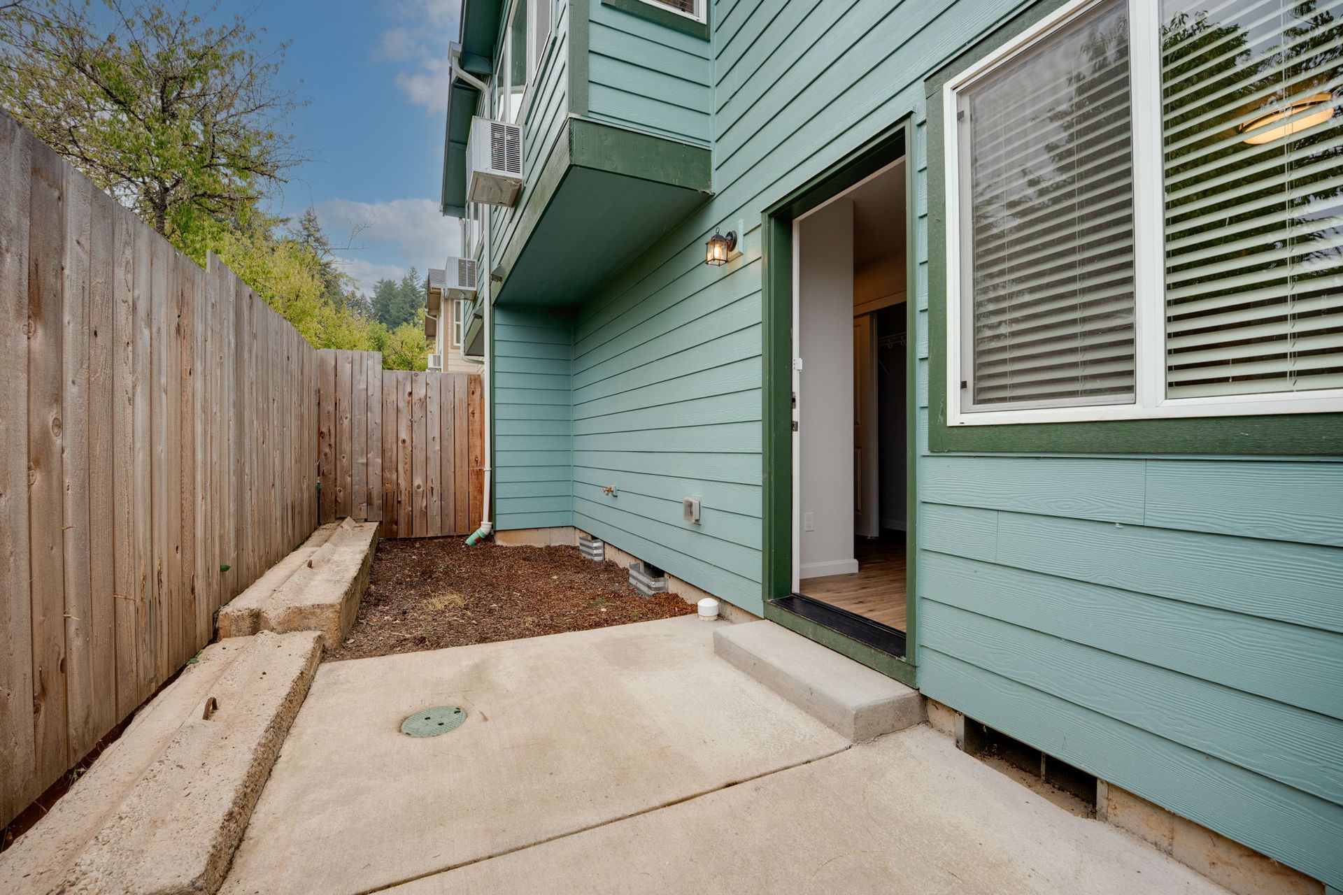 back patio with concrete pad and bark mulch yard