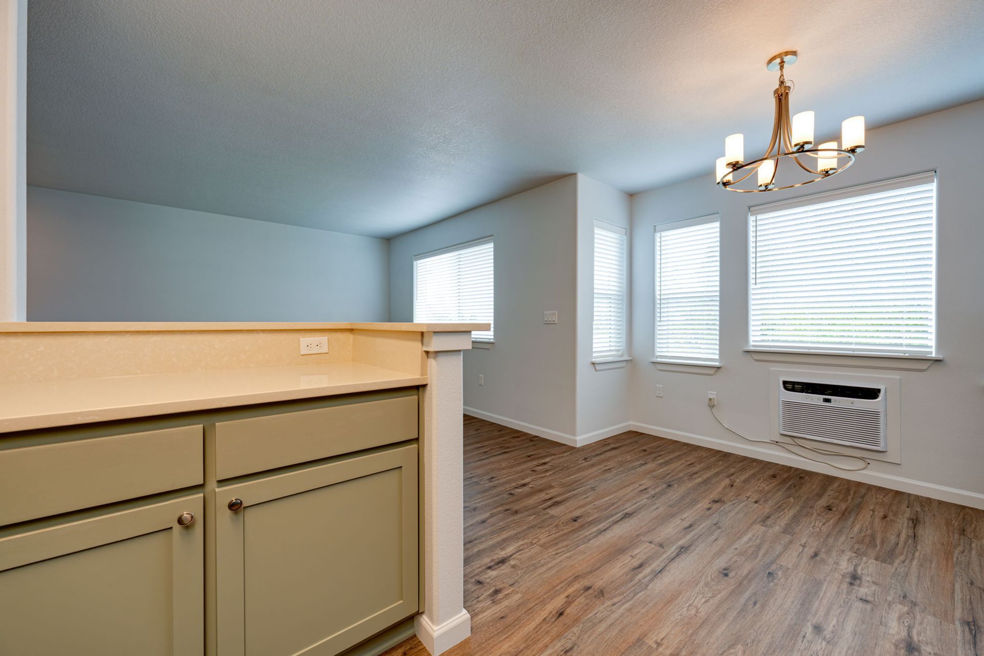 view from kitchen into unfurnished dining room and living room in the background