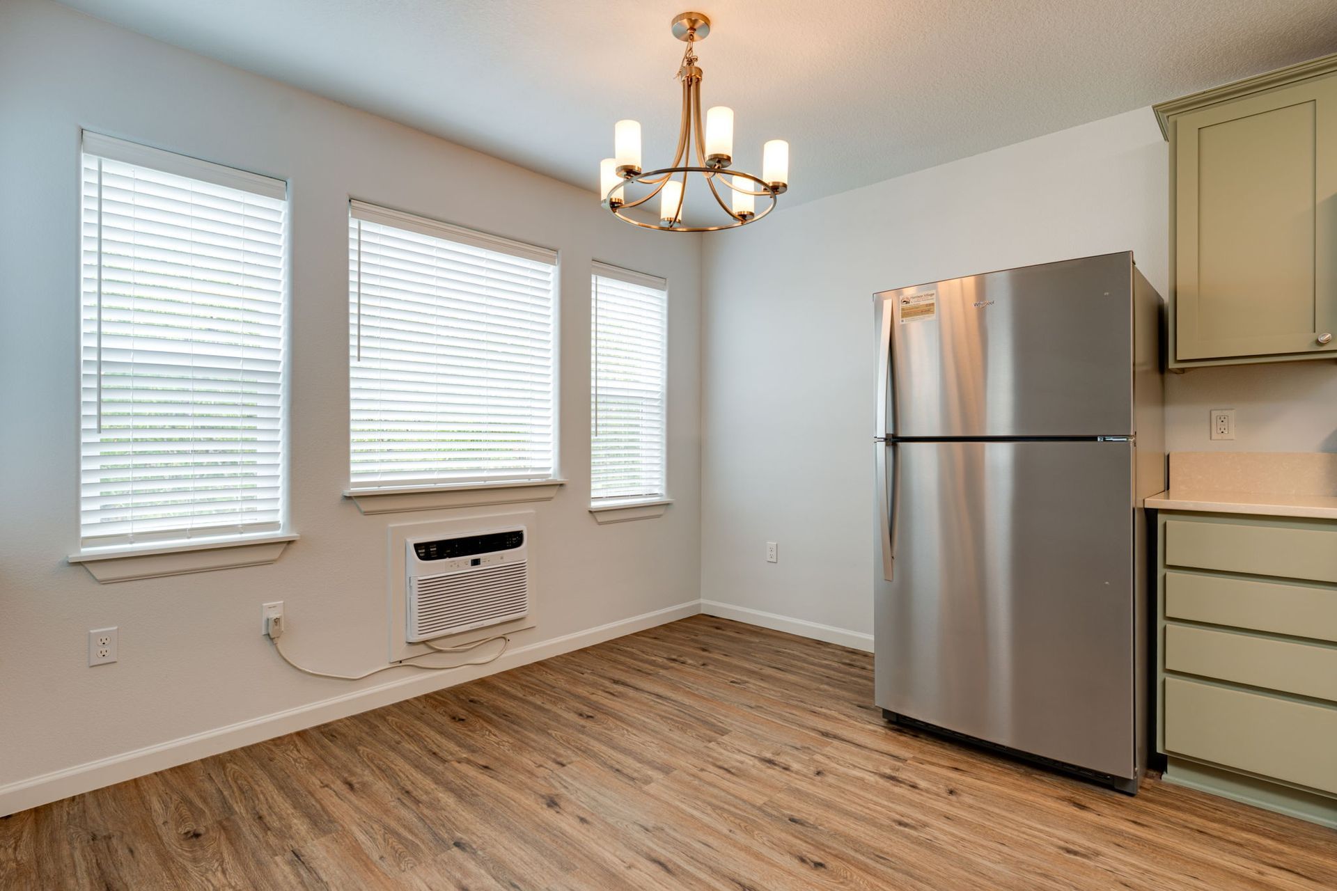 view of dining room with A/C below windows and refridgerator in the background.