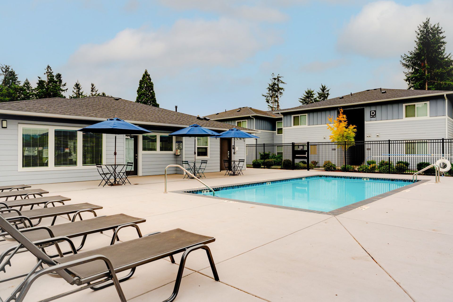Photo of pool with clubhouse in the background at Harrison Village.