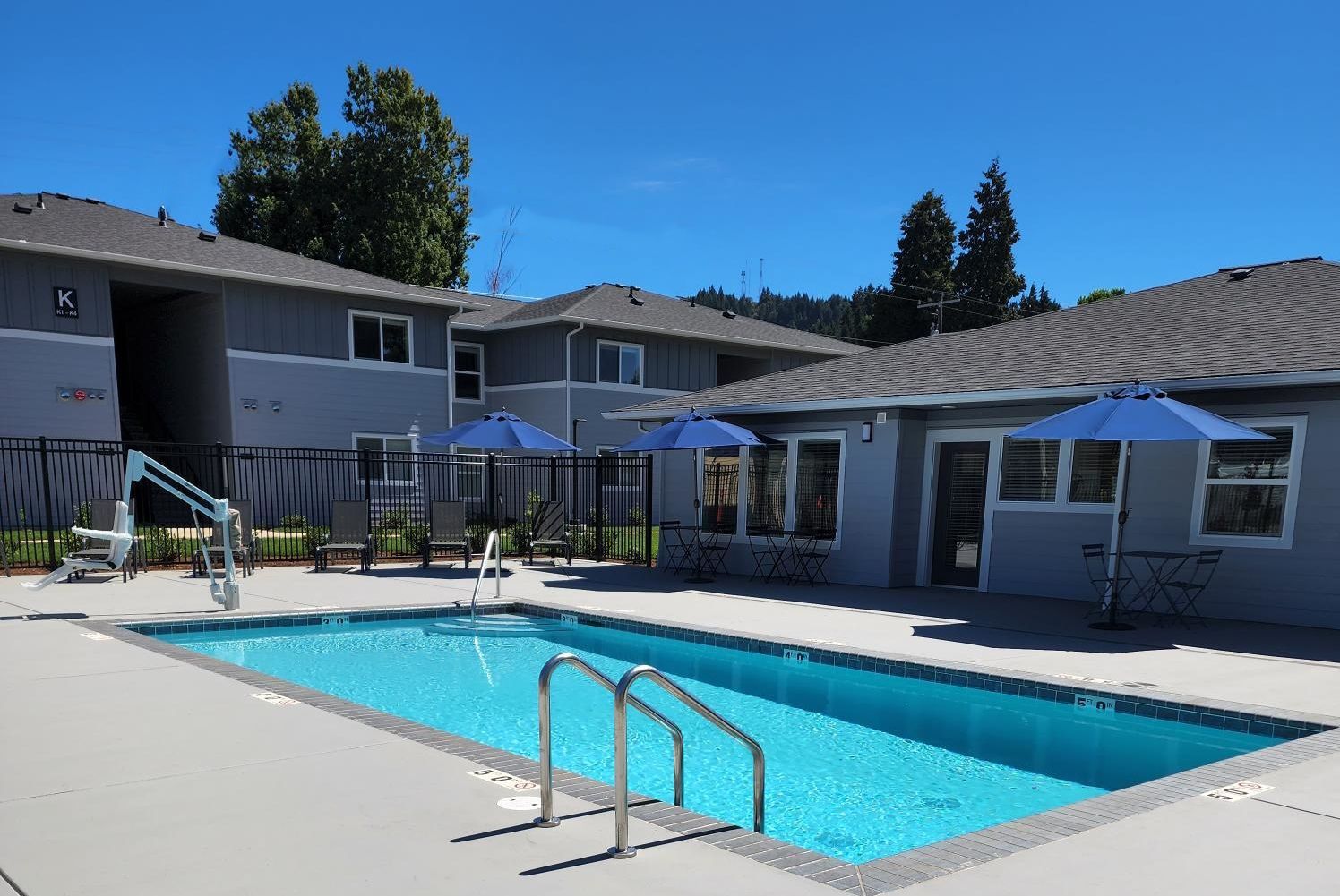 Photo of pool with clubhouse in the background at Harrison Village.