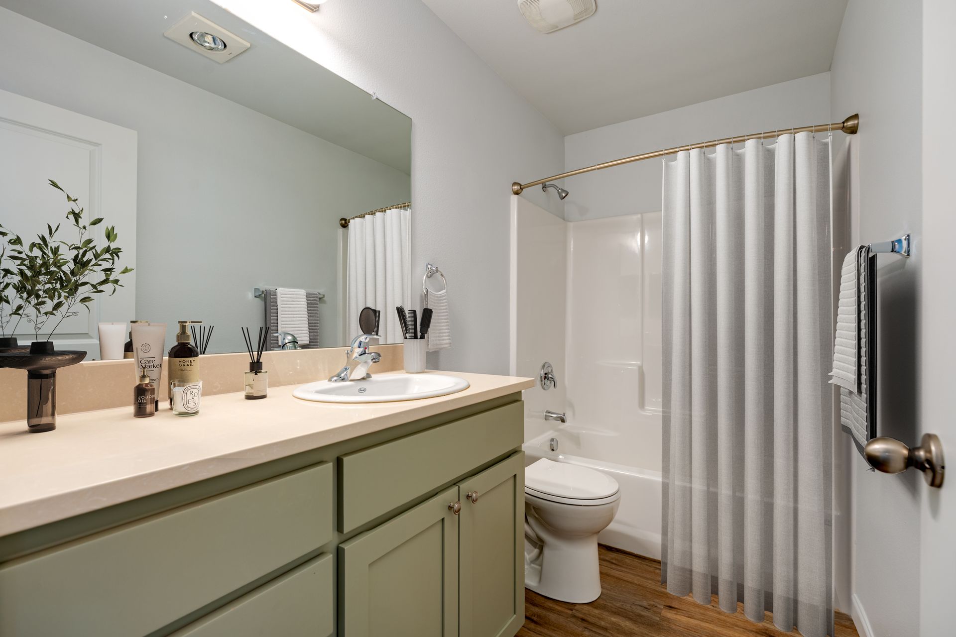 staged bathroom showing vanity, toilet and shower/tub