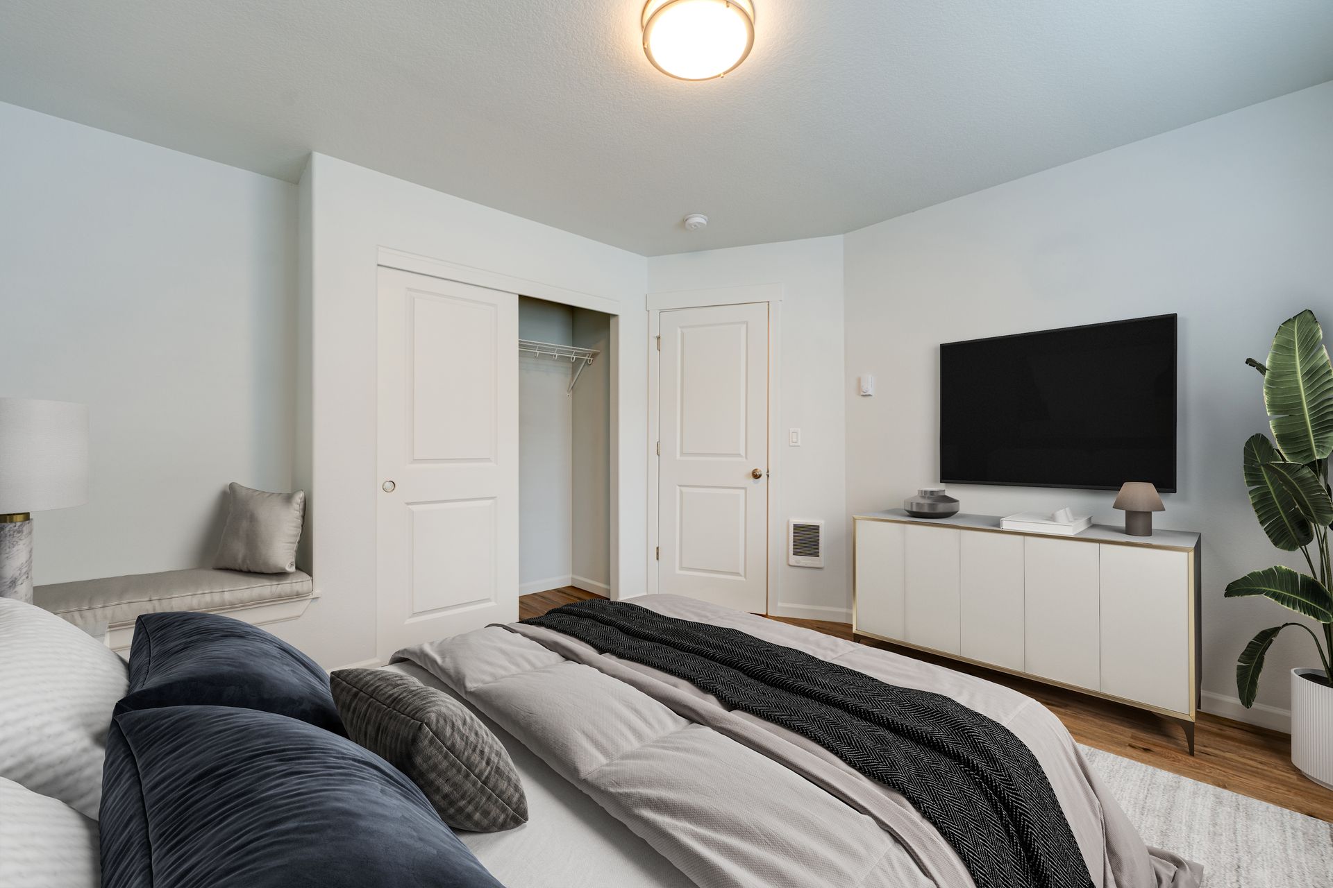 first second-floor bedroom furnished with door, closet and sitting nook in the background