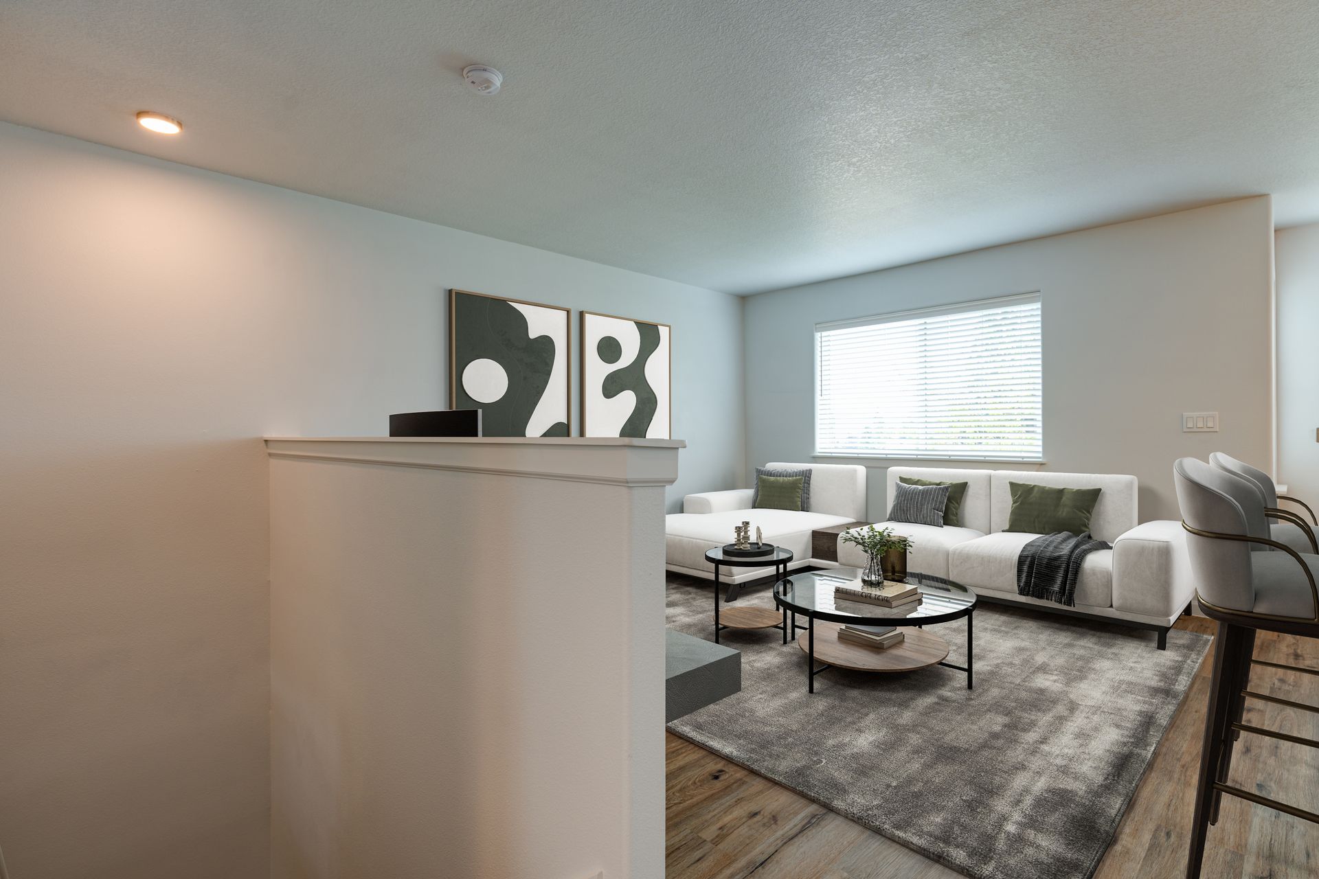 view into furnished living room from the top of stairs looking over pony wall