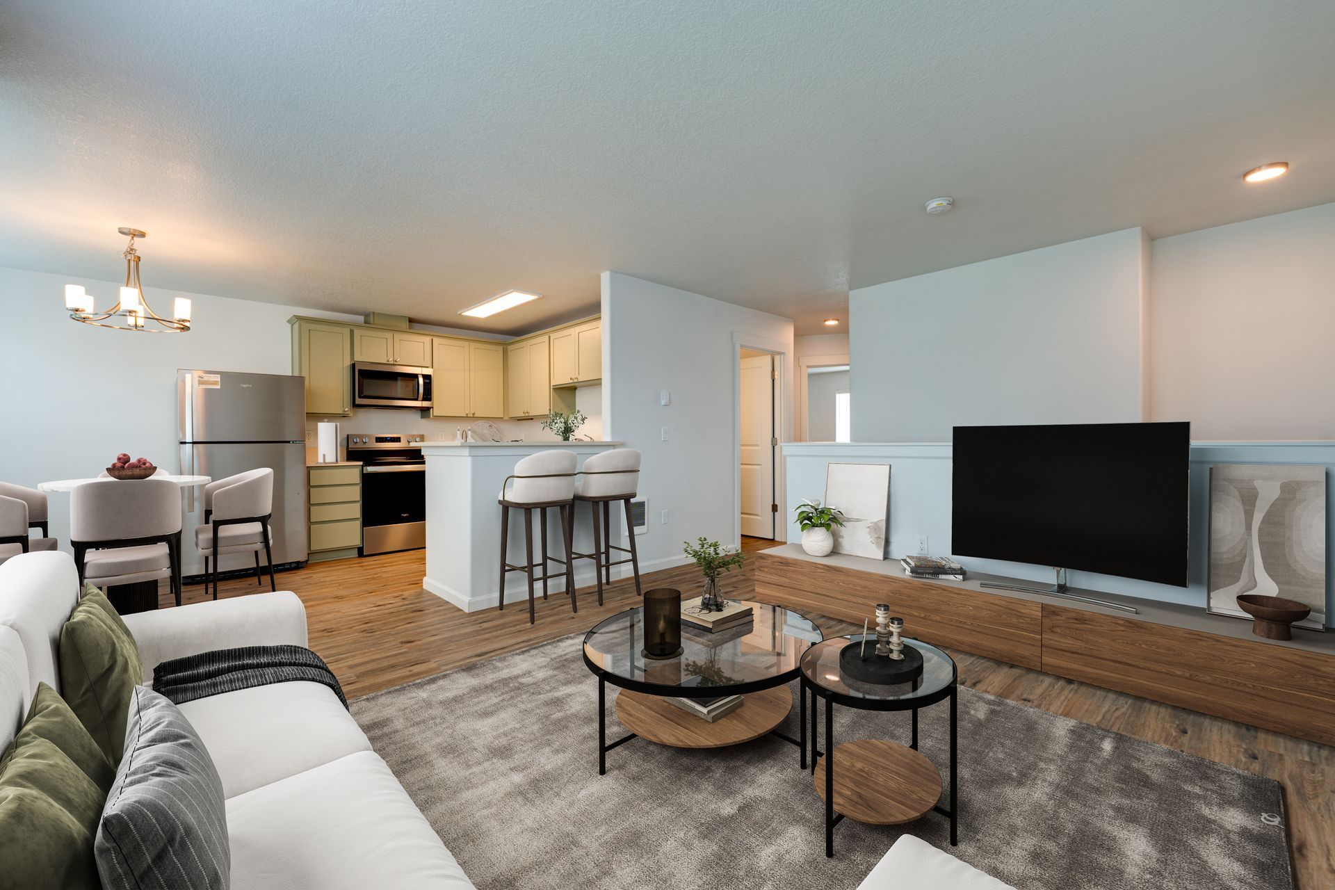view of furnished living room with kitchen and hallway to bedrooms in the background