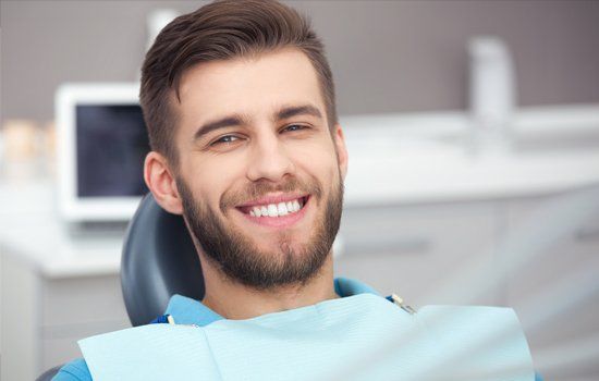 Dentist — Portrait of Happy Patient in Dental Chair in Lafayette, IN
