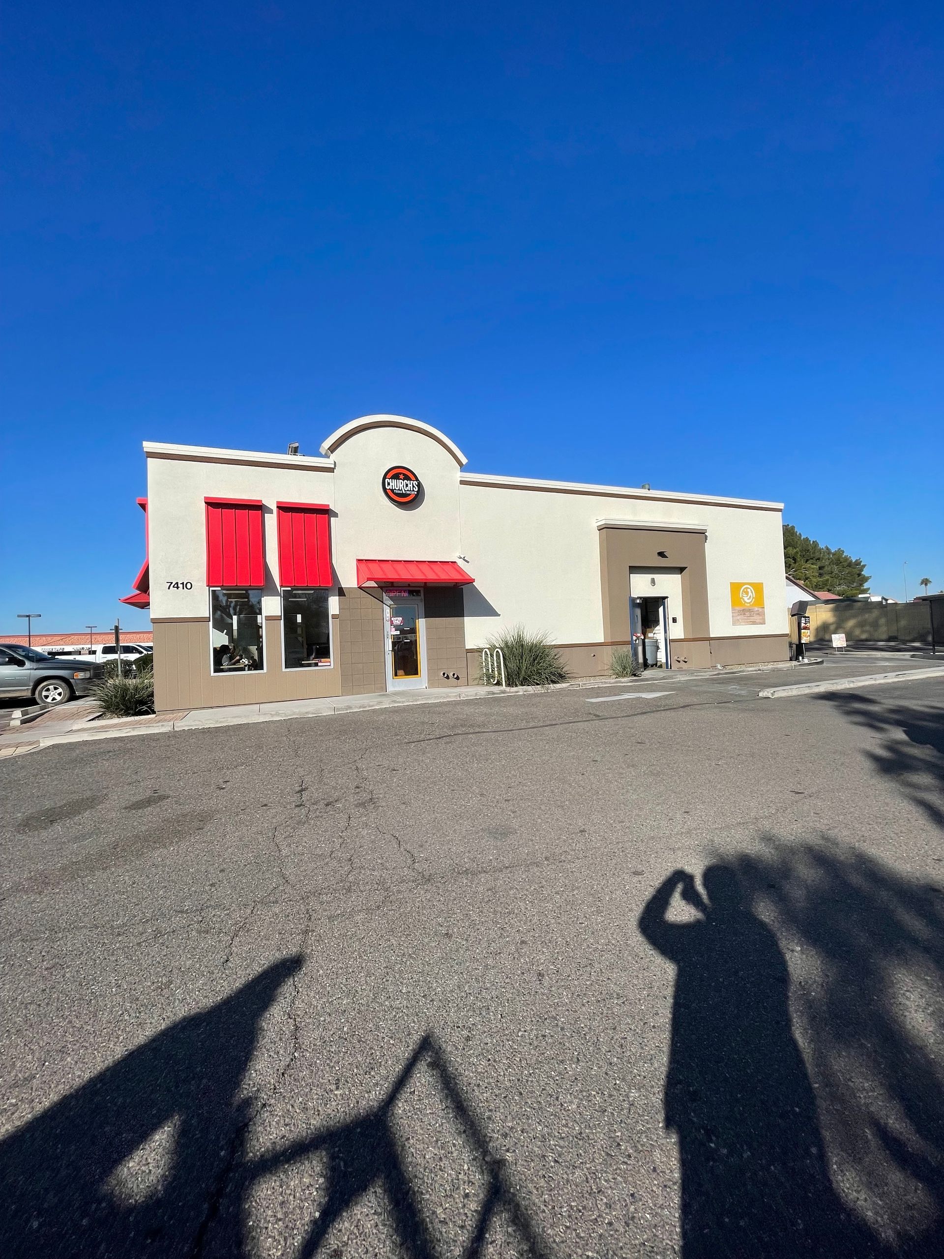 A shadow of a person standing in front of a building