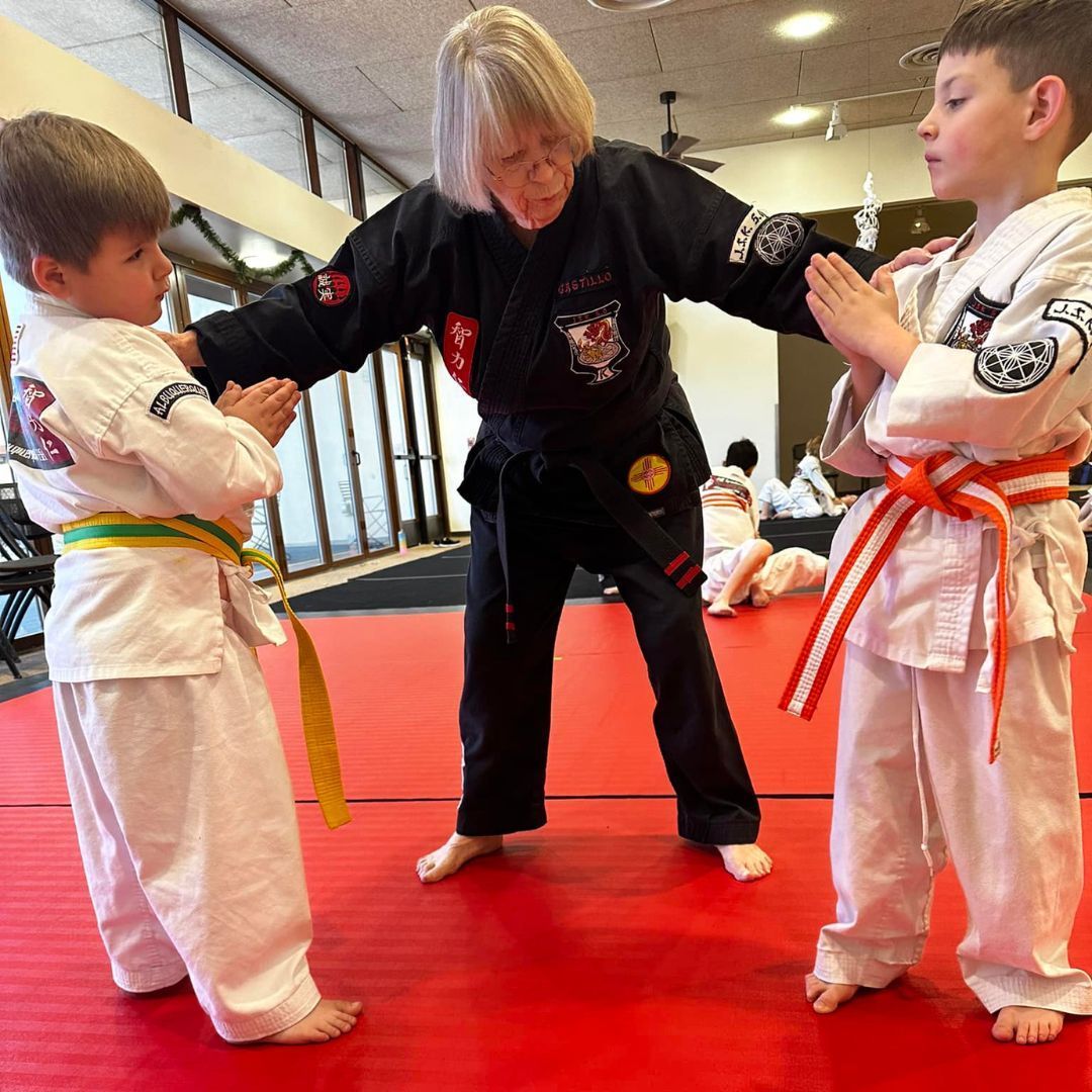 A man and a woman are practicing karate in a gym.