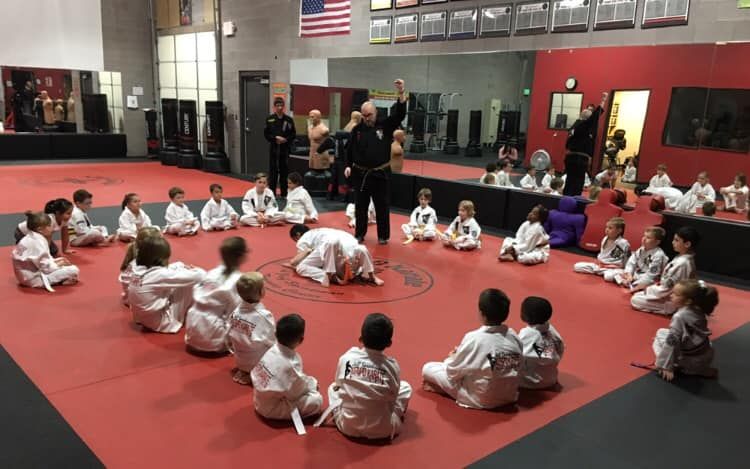 A young girl is practicing taekwondo in a gym.