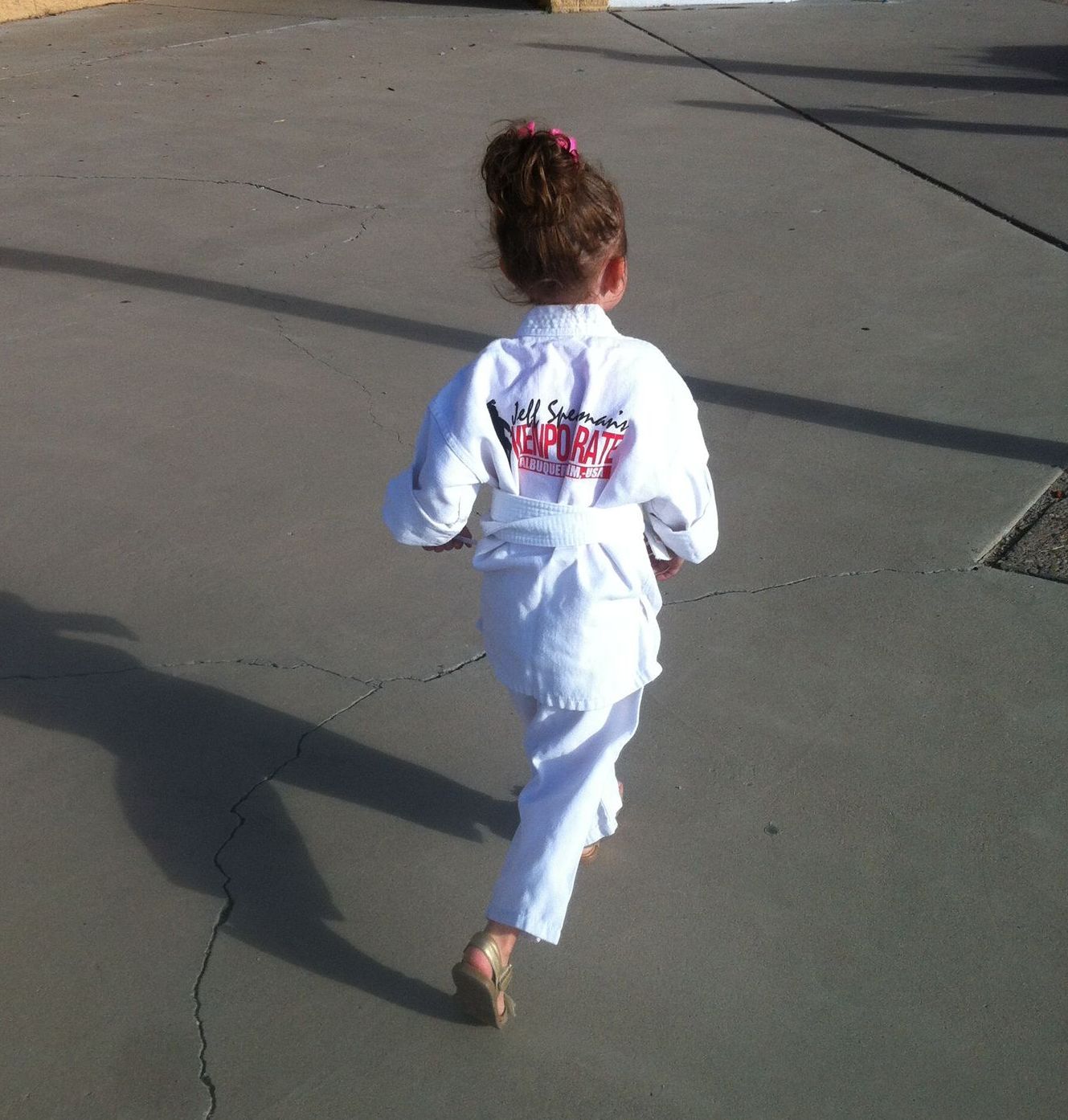 A group of young girls are practicing karate in a gym.