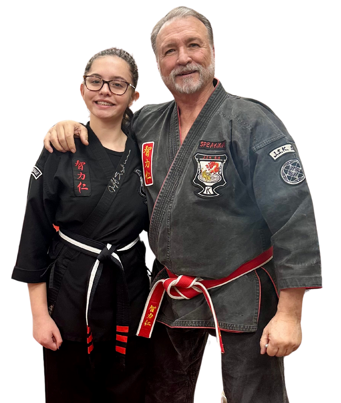 A boy and two girls are wearing karate uniforms and pointing at the camera