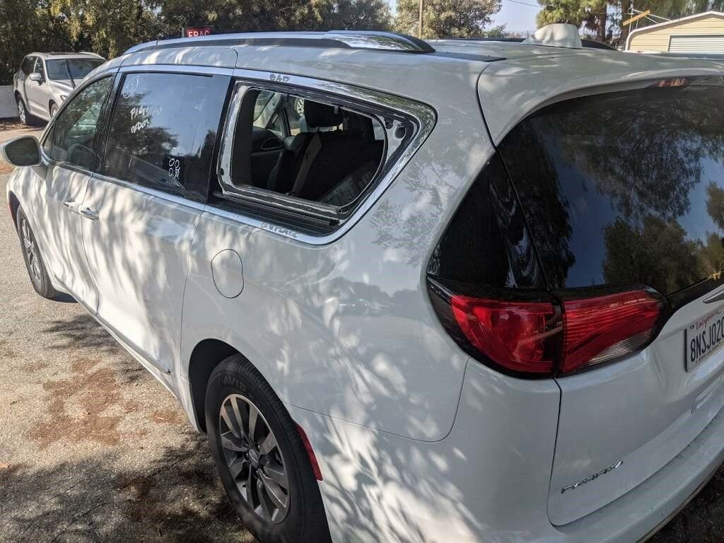 A white chrysler pacifica is parked in a parking lot.