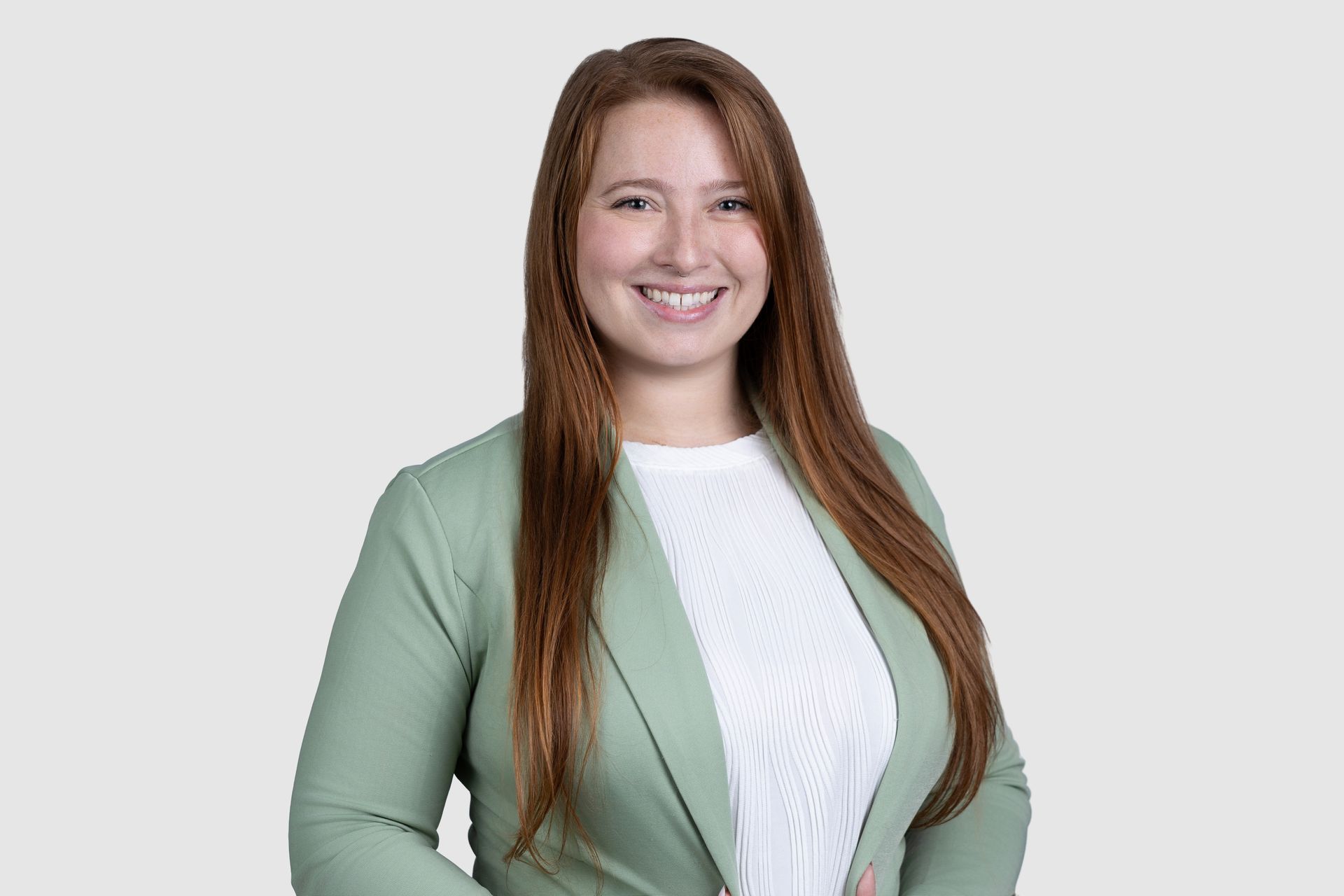 A woman is sitting at a table in front of a window.