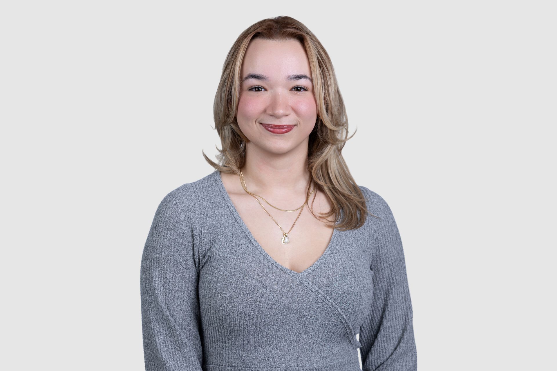 A woman wearing a black polka dot shirt is smiling for the camera